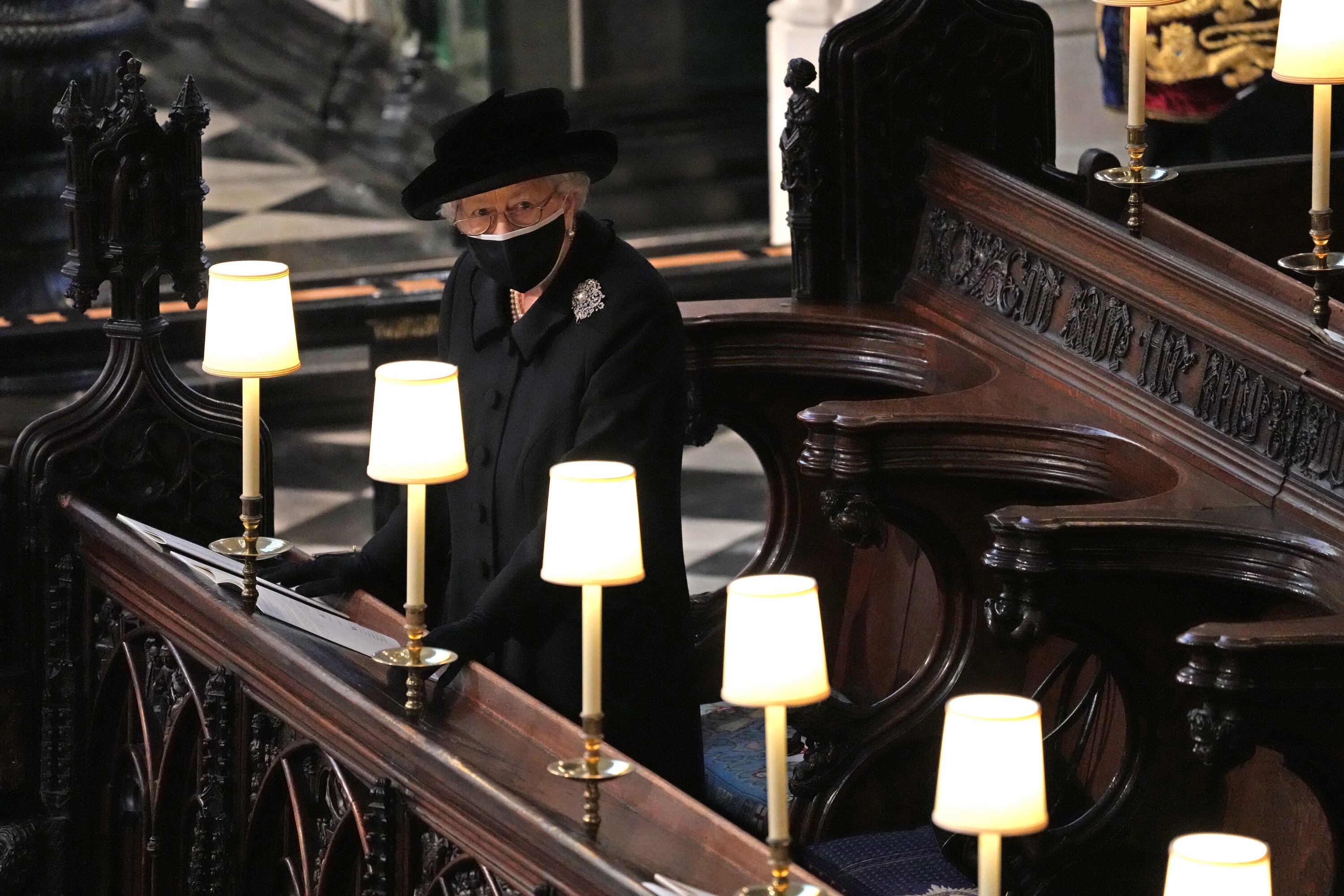 WINDSOR, ENGLAND - APRIL 17: Queen Elizabeth II watches as pallbearers carry the coffin of Prince Philip, Duke Of Edinburgh into St George’s Chapel by the pallbearers during the funeral of Prince Philip, Duke of Edinburgh at Windsor Castle on April 17, 2021 in Windsor, United Kingdom. Prince Philip of Greece and Denmark was born 10 June 1921, in Greece. He served in the British Royal Navy and fought in WWII. He married the then Princess Elizabeth on 20 November 1947 and was created Duke of Edinburgh, Earl of Merioneth, and Baron Greenwich by King VI. He served as Prince Consort to Queen Elizabeth II until his death on April 9 2021, months short of his 100th birthday. His funeral takes place today at Windsor Castle with only 30 guests invited due to Coronavirus pandemic restrictions. (Photo by Yui Mok-WPA Pool/Getty Images)