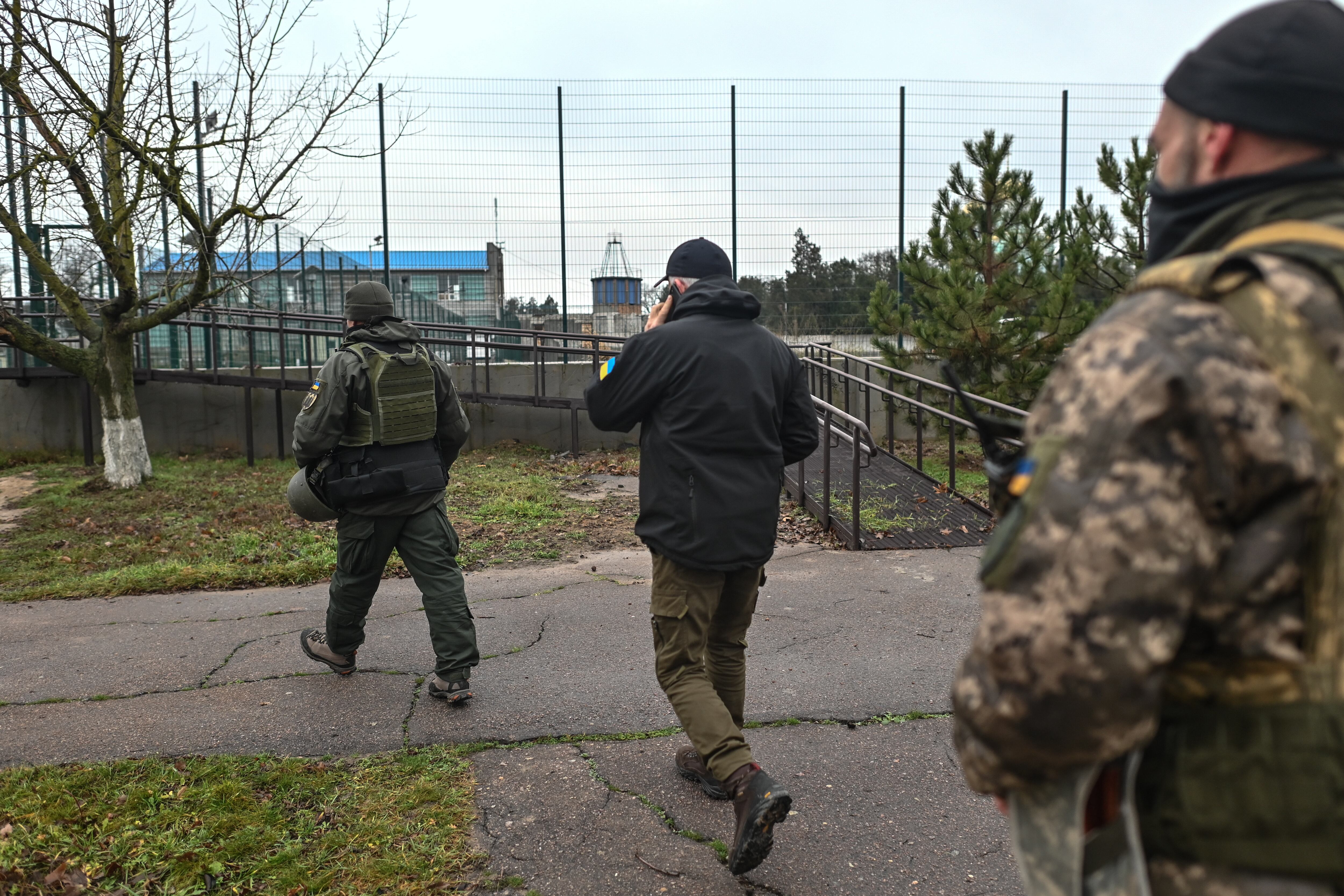 El alcalde de Chornobaivka, Ihor Dudar, rodeado de guardaespaldas, regresa a su oficina en Chornobaivka, Ucrania, el 13 de diciembre de 2022.