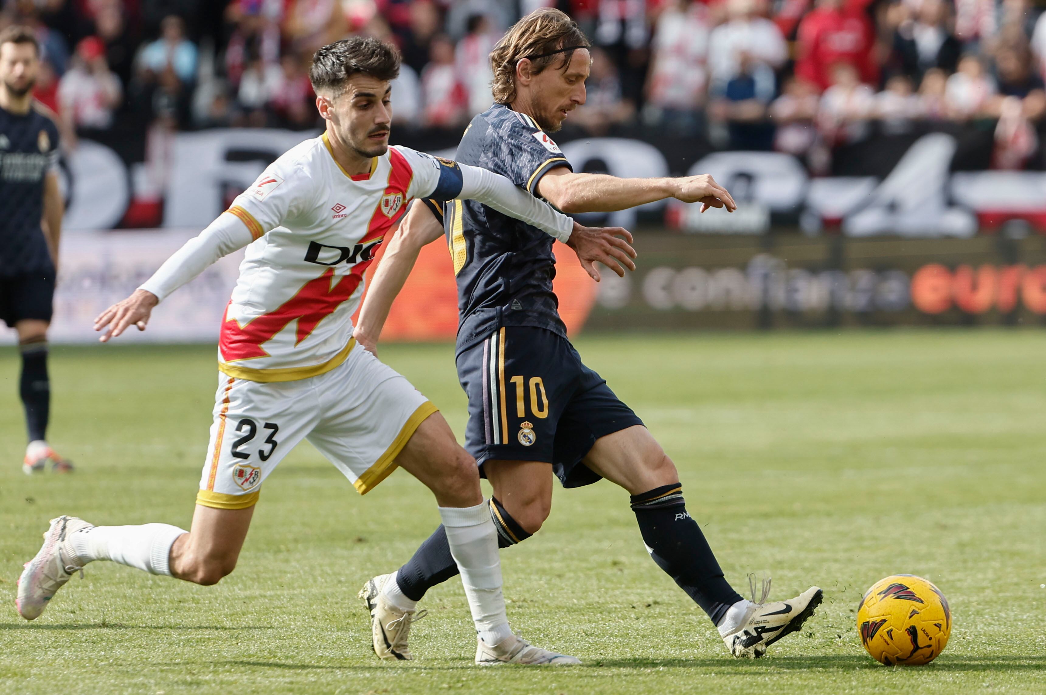El centrocampista del Rayo Vallecano Óscar Valentín (i) disputa el balón con Modric durante el partido entre el Rayo Vallecano y el Real Madrid correspondiente a la jornada 25 de LaLiga, este domingo en el Estadio Vallecas en Madrid. EFE/ Sergio Pérez