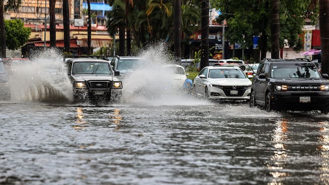 MEX2671. ACAPULCO (MEXICO), 16/08/2023.- Vehículos transitan por una calle inundada debido a las fuertes lluvias hoy, en el balneario de Acapulco, estado de Guerrero (México). México prevé que la tormenta tropical Hilary, octavo ciclón con nombre en la temporada y formada este miércoles, se intensifique el jueves a huracán en su paso por las costas de los estados de Colima y Jalisco, informó este miércoes el Servicio Meteorológico Nacional (SMN). EFE/David Guzmán
