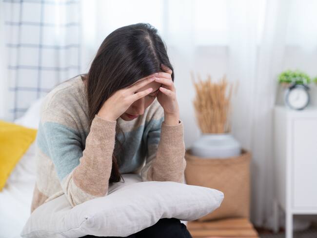 Woman suffering from stress or a headache grimacing in pain
