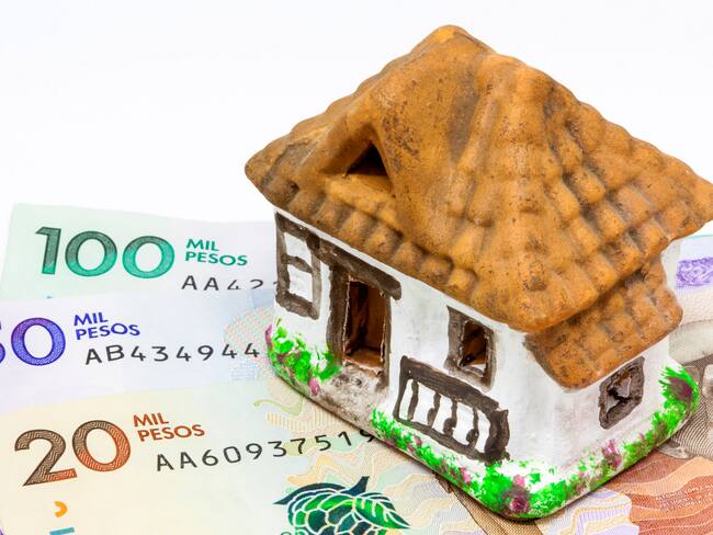 Escultura de una casa y dinero colombiano. (Foto: Getty Images)