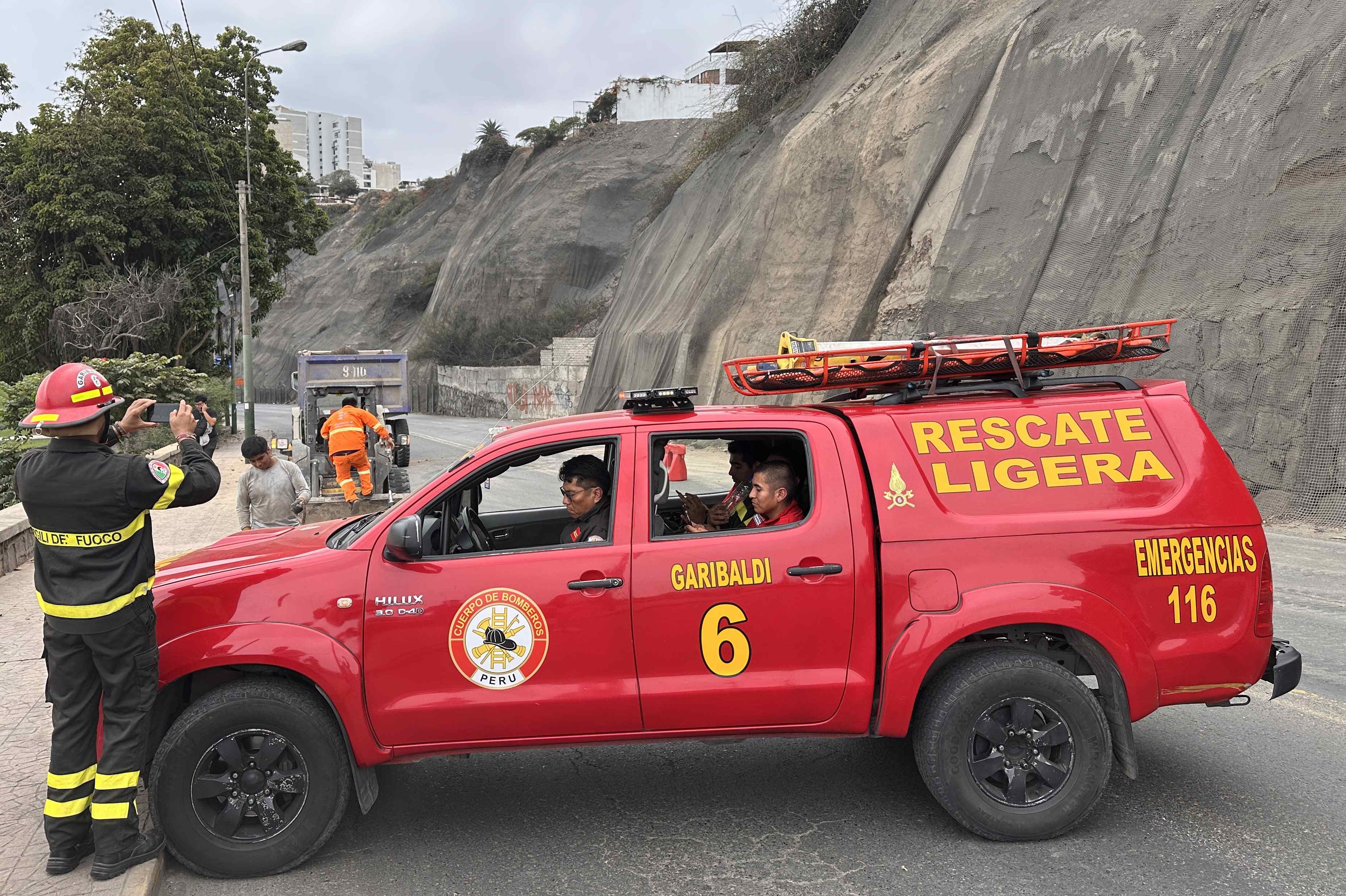 Integrantes de equipos de rescate cierran la avenida Costa Verde por derrumbes en el acantilado, producto del sismo ocurrido este domingo, en Lima (Perú). EFE/Mikhail Huacán