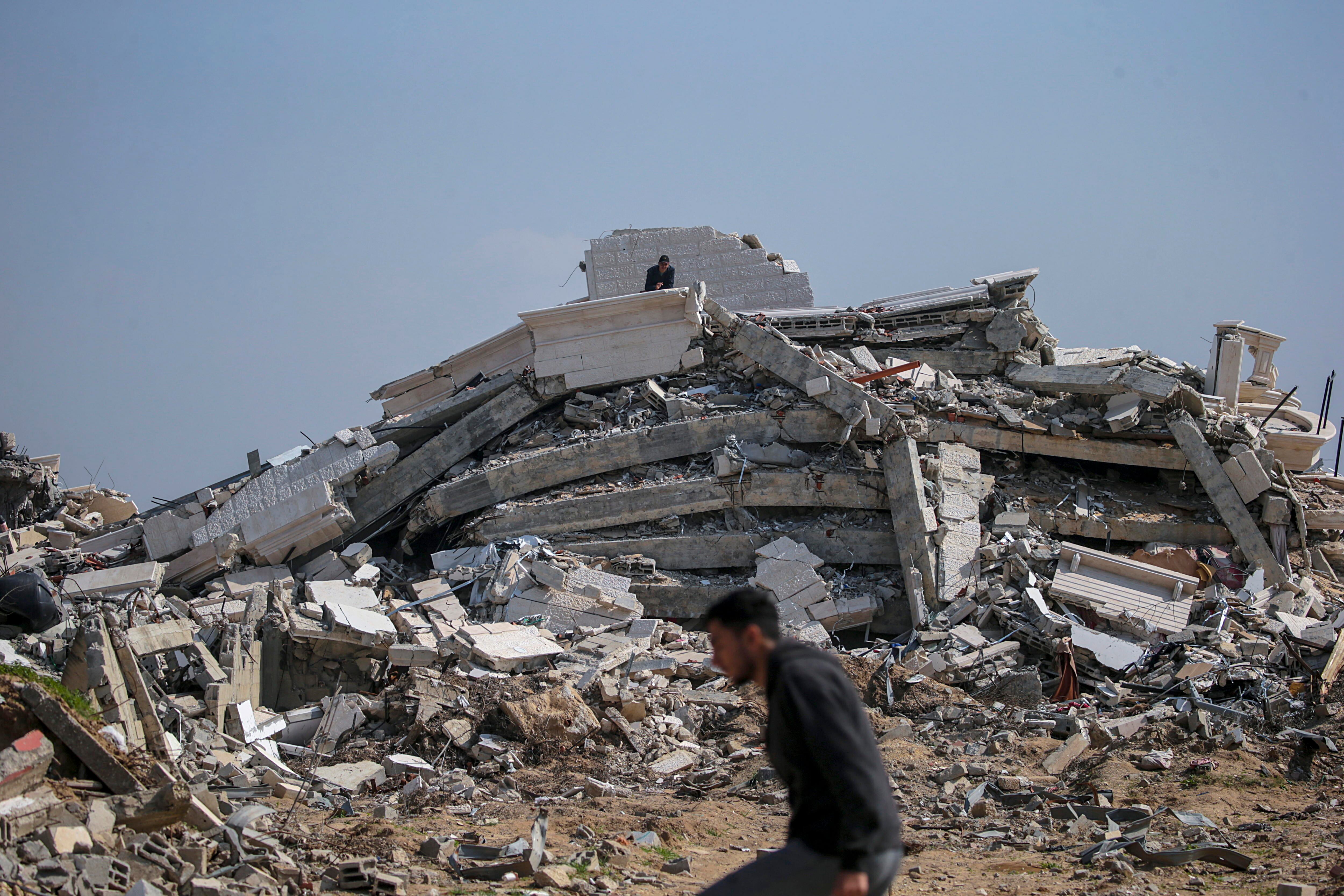 Al Nuseirat Camp (-), 28/02/2024.- A Palestinian man (rear) stands on top of the rubble of his destroyed house in the east of Al Nuseirat refugee camp, central Gaza Strip, 28 February 2024, following Israeli air strikes. More than 29,900 Palestinians and over 1,300 Israelis have been killed, according to the Palestinian Health Ministry and the Israel Defense Forces (IDF), since Hamas militants launched an attack against Israel from the Gaza Strip on 07 October 2023, and the Israeli operations in Gaza and the West Bank which followed it. EFE/EPA/MOHAMMED SABER