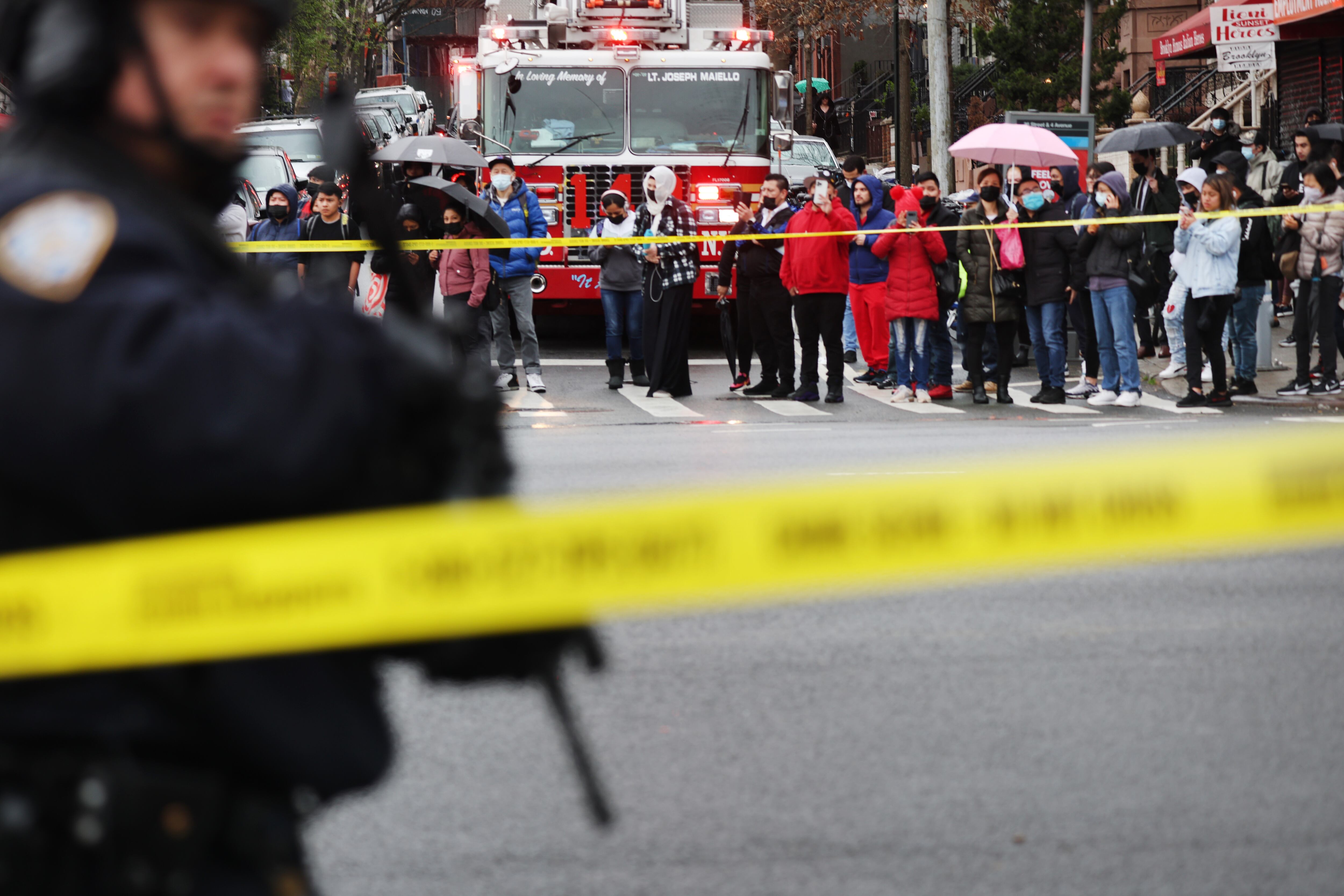 NEW YORK, NEW YORK - APRIL 12: Onlookers watch as police and emergency responders gather at the site of a reported shooting of multiple people outside of the 36 St subway station on April 12, 2022 in the Brooklyn borough of New York City. According to authorities, multiple people have reportedly been shot and several undetonated devices were discovered at the 36th Street and Fourth Avenue station in the Sunset Park neighborhood. (Photo by Spencer Platt/Getty Images)
