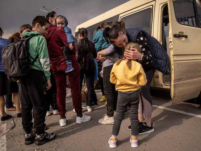 ZAPORIZHZHIA, UKRAINE - MAY 02: A woman kisses a girl after arriving at an evacuation point for people fleeing Mariupol, Melitopol and the surrounding towns under Russian control on May 02, 2022 in Zaporizhzhia, Ukraine.Dozens of refugees were expected to arrive here from Mariupol, including the Azovstal steel facility, following extensive negotiations between representatives of Ukraine, Russia, the United Nations and the International Committee of the Red Cross. (Photo by Chris McGrath/Getty Images)