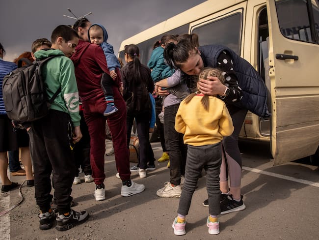 ZAPORIZHZHIA, UKRAINE - MAY 02: A woman kisses a girl after  arriving at an evacuation point for people fleeing Mariupol, Melitopol and the surrounding towns under Russian control on May 02, 2022 in Zaporizhzhia, Ukraine.Dozens of refugees were expected to arrive here from Mariupol, including the Azovstal steel facility, following extensive negotiations between representatives of Ukraine, Russia, the United Nations and the International Committee of the Red Cross. (Photo by Chris McGrath/Getty Images)