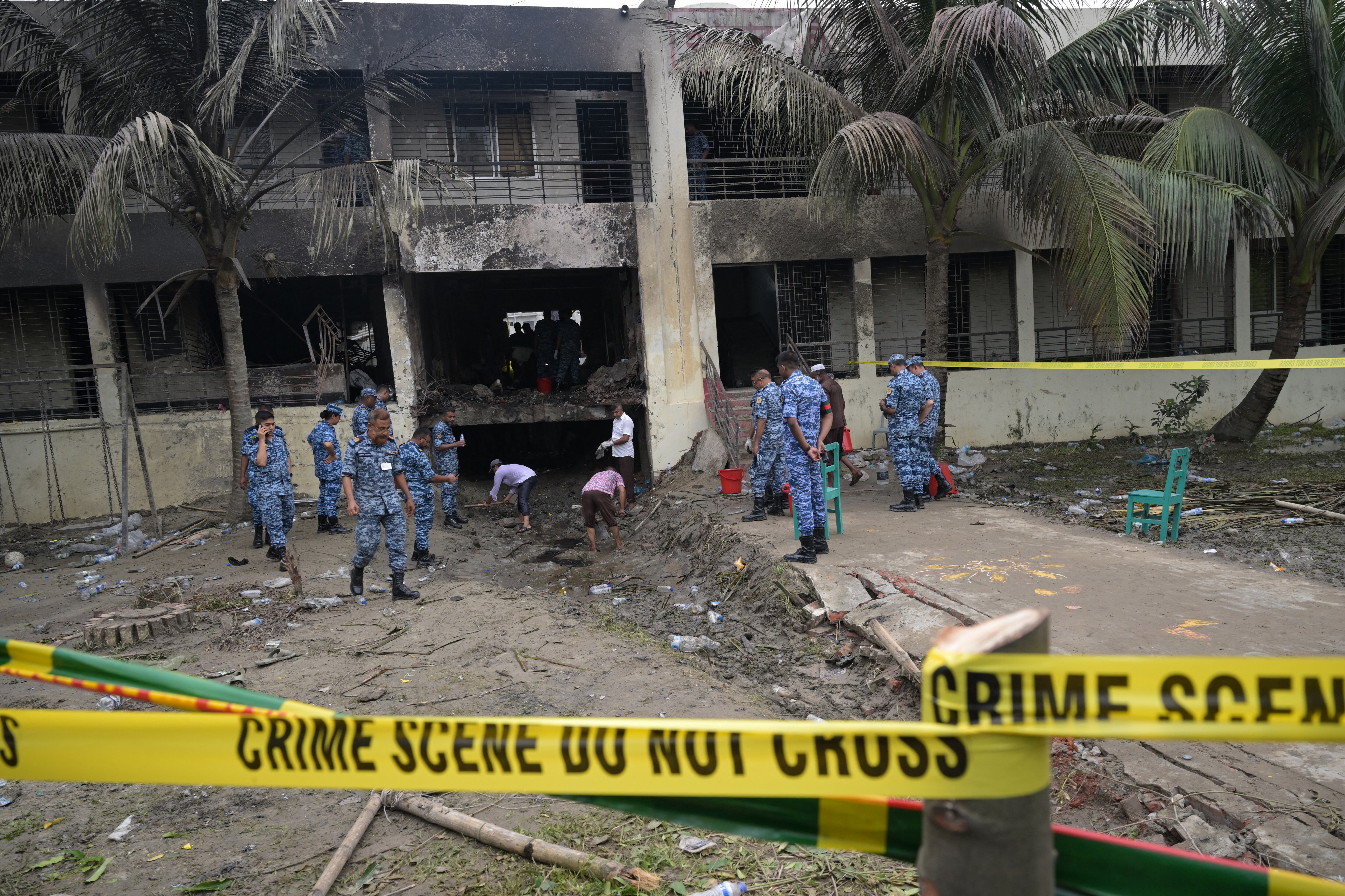 Bangladesh Air Force personnel inspect the crash site a day after a training jet crashed into a school in Dhaka on July 22, 2025. A Bangladeshi fighter jet crashed into a school in the capital Dhaka on July 21, 2025, killing at least 20 people and injuring more than 170 in the country's deadliest aviation accident in decades. (Photo by MUNIR UZ ZAMAN / AFP)