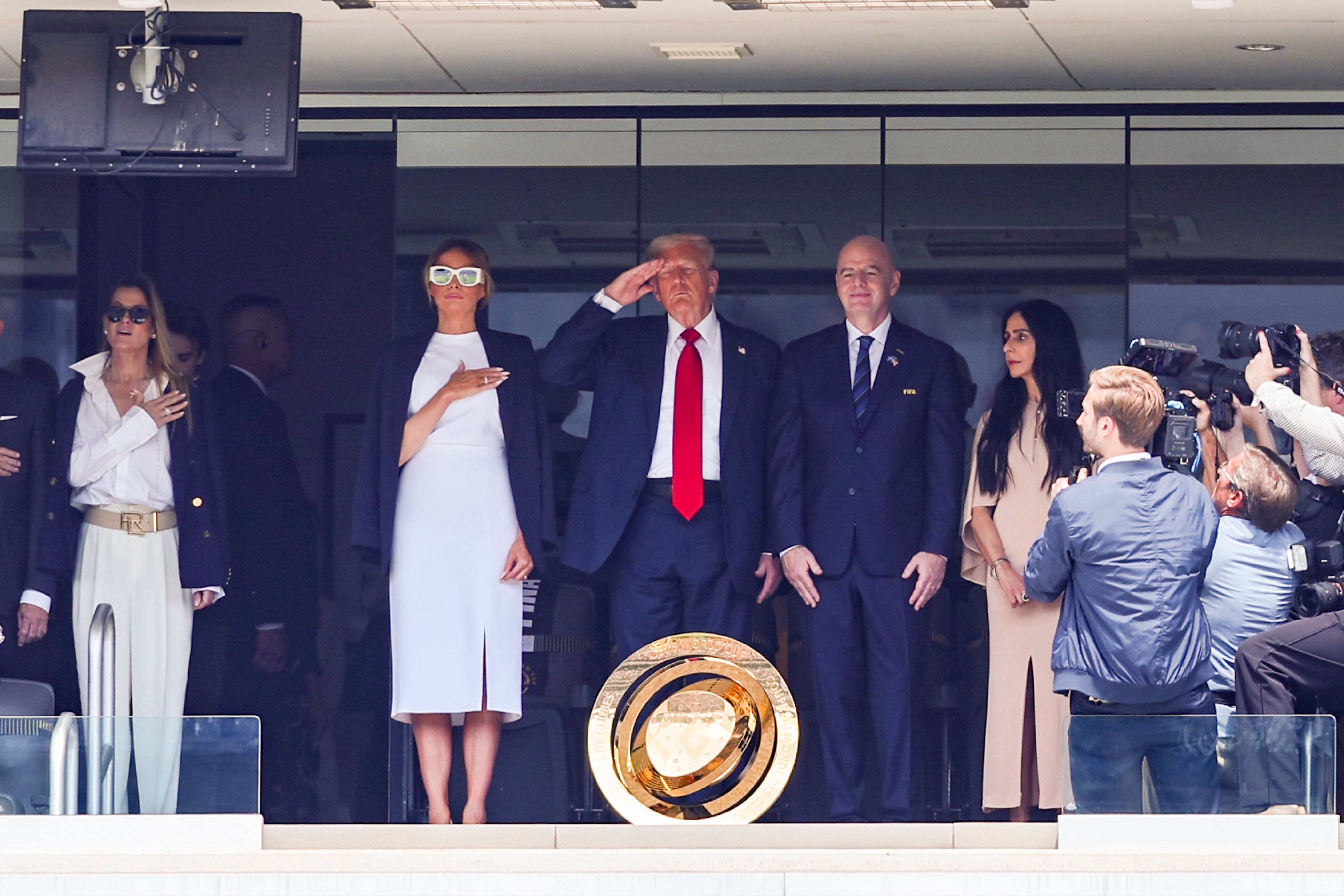  President of the United States, Donald J Trump (C) salutes from the stand with his wife Melania Trump (L) and FIFA President Gianni Infantino. (Photo by Joao Bravo/Sports Press Photo/Getty Images)