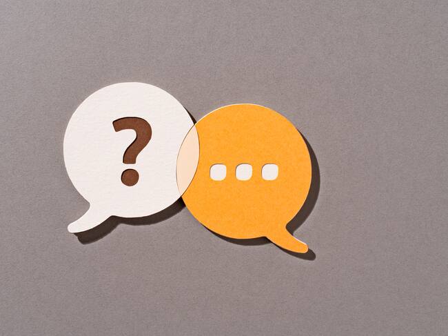 Paper Craft of Orange Color Question and Answer Speech Bubbles Overlapping on Brown Background Front View.