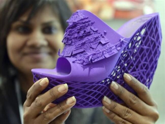 Una azafata muestra un zueco fabricado con una impresora en 3D durante la Feria CES de electrónica en Las Vegas. Foto: Efe.