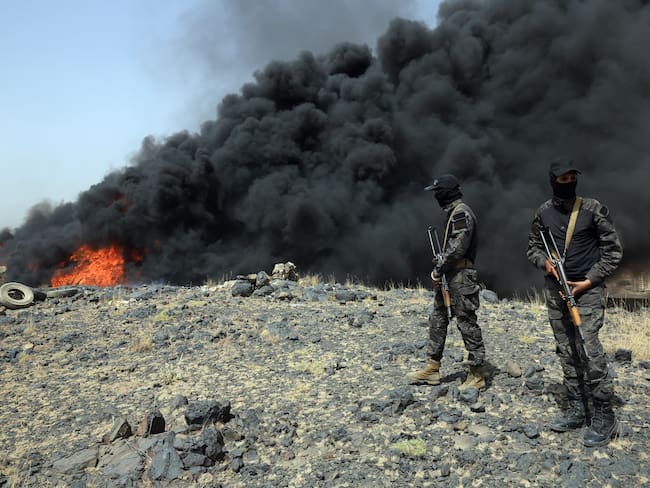 SANA'A (Yemen), 01/07/2025.- Soldiers keep watch as flames and smoke rise from a burning pile of confiscated narcotics, in Sana'a, Yemen, 01 July 2025. The Houthis-held security service has incinerated and destroyed a large quantity of confiscated narcotics, which were seized from smugglers in several areas of war-torn Yemen since mid-2024. The illegal drugs included over 18 tons of drug hashish, over 205,000 captagon pills, and 12.3 million pregabalin pills, according to a statement by the Houthis-run ministry of interior. EFE/EPA/YAHYA ARHAB