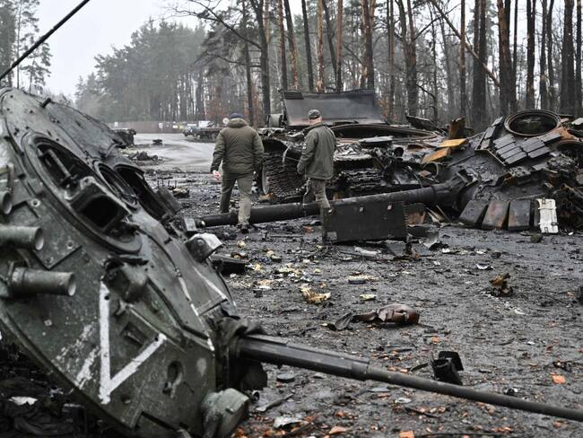Militares ucranianos caminan junto a tanques destruidos (Photo by Genya SAVILOV / AFP) (Photo by GENYA SAVILOV/AFP via Getty Images)