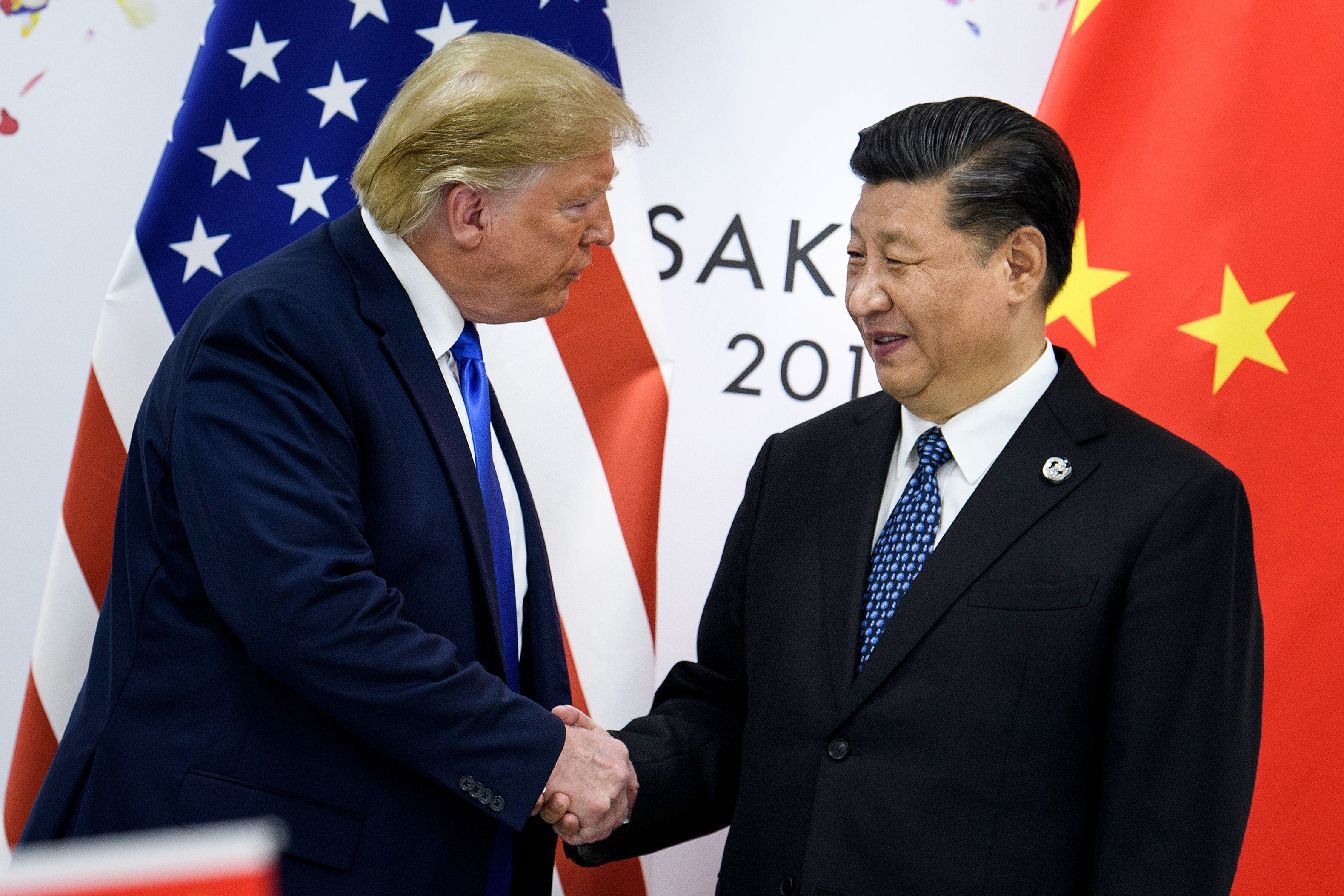 En esta foto de archivo tomada el 28 de junio de 2019, el presidente de China, Xi Jinping (d), estrecha la mano del presidente de Estados Unidos, Donald Trump, antes de una reunión bilateral al margen de la Cumbre del G20 en Osaka. (BRENDAN SMIALOWSKI/AFP vía Getty Images)
