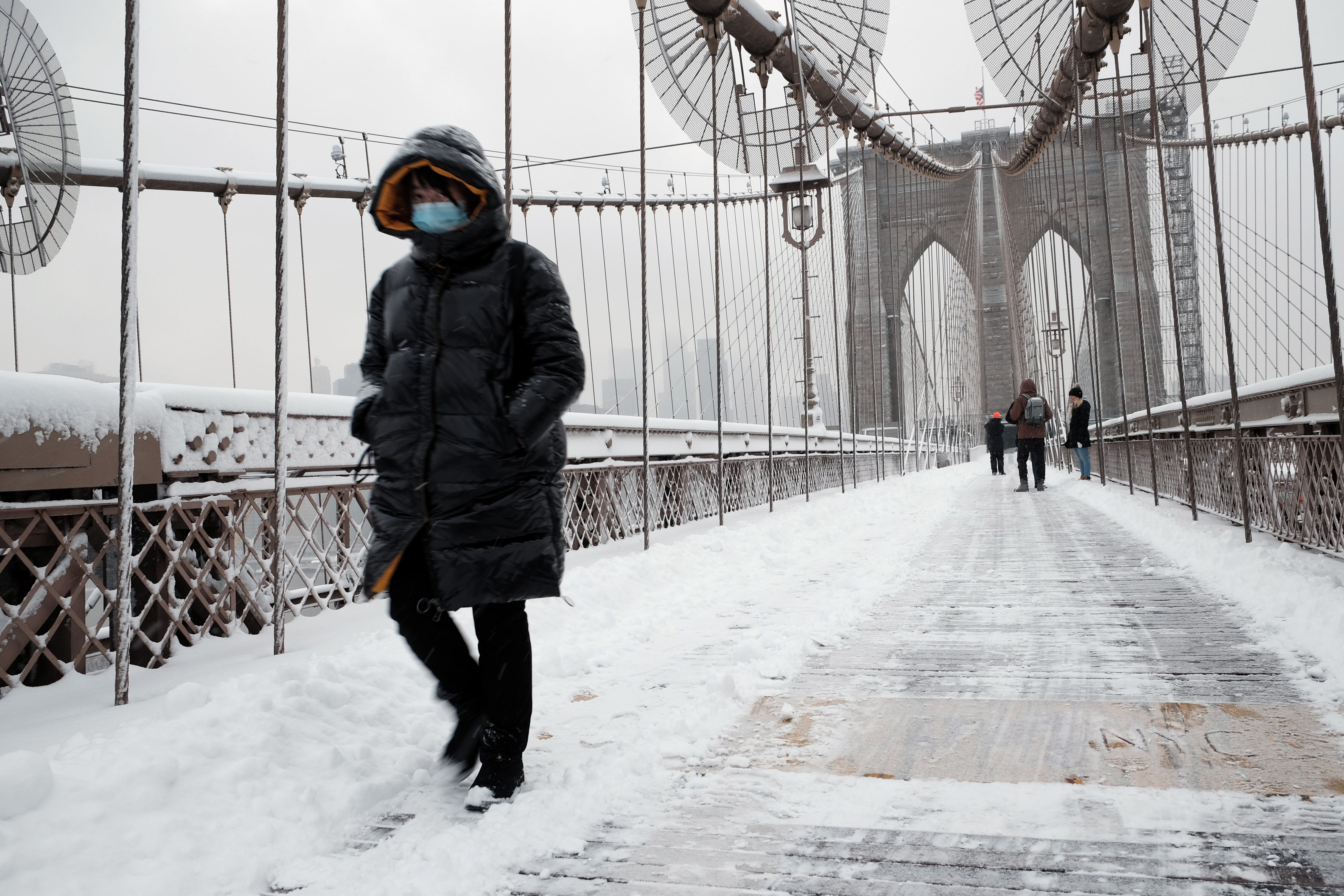 NEW YORK CITY - JANUARY 07: A person walks through the snow on the Brooklyn Bridge in Manhattan on January 07, 2022 in New York City. New York City and much of the tri-state region received over four inches of snow in what is the first significant snow accumulation of the season.  (Photo by Spencer Platt/Getty Images)