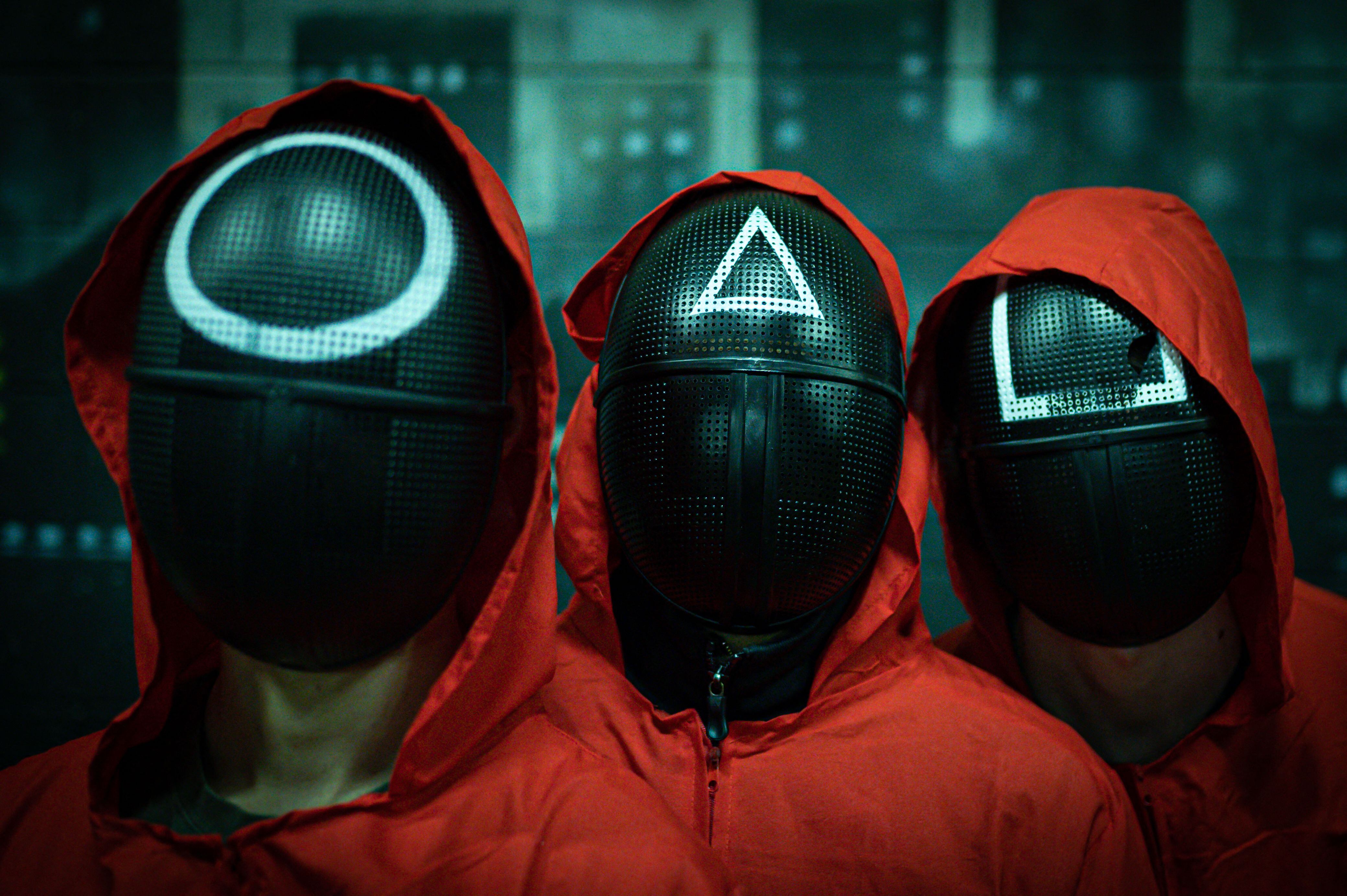 Masked actors pose during an event organized by the Enigma Room escape game in Milan on November 14, 2021, where participants play some of the games of the world-famous South Korean TV survival drama television series "Squid Game". (Photo by Piero CRUCIATTI / AFP) (Photo by PIERO CRUCIATTI/AFP via Getty Images)