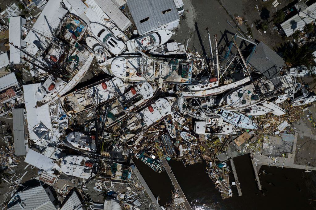 An aerial picture taken on September 29, 2022 shows piled up boats in the aftermath of Hurricane Ian in Fort Myers, Florida. - Hurricane Ian left much of coastal southwest Florida in darkness early on Thursday, bringing "catastrophic" flooding that left officials readying a huge emergency response to a storm of rare intensity. The National Hurricane Center said the eye of the "extremely dangerous" hurricane made landfall just after 3:00 pm (1900 GMT) on the barrier island of Cayo Costa, west of the city of Fort Myers. (Photo by Ricardo ARDUENGO / AFP) (Photo by RICARDO ARDUENGO/AFP via Getty Images)
