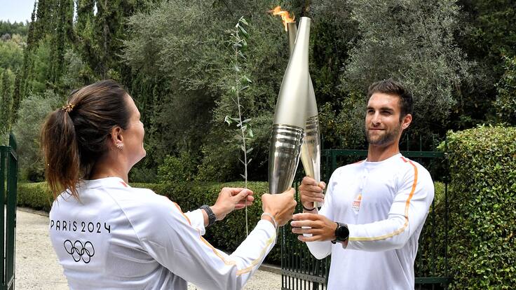 Ancient Olympia (Greece), 16/04/2024.- First torchbearer Greek Rowing Olympic Champion Stefanos Ntouskos (R), passes the Olympic Flame to the France Swimming Olympic champion Laure Manaudou (L) during the Lighting Ceremony of the Olympic Flame for the Paris 2024 Olympic Games, in Archaia Olympia, Greece, 16 April 2024. The Summer Olympics Games will be held in Paris, France from 26 July to 11 August 2024. (Francia, Grecia) EFE/EPA/VASSILIS PSOMAS