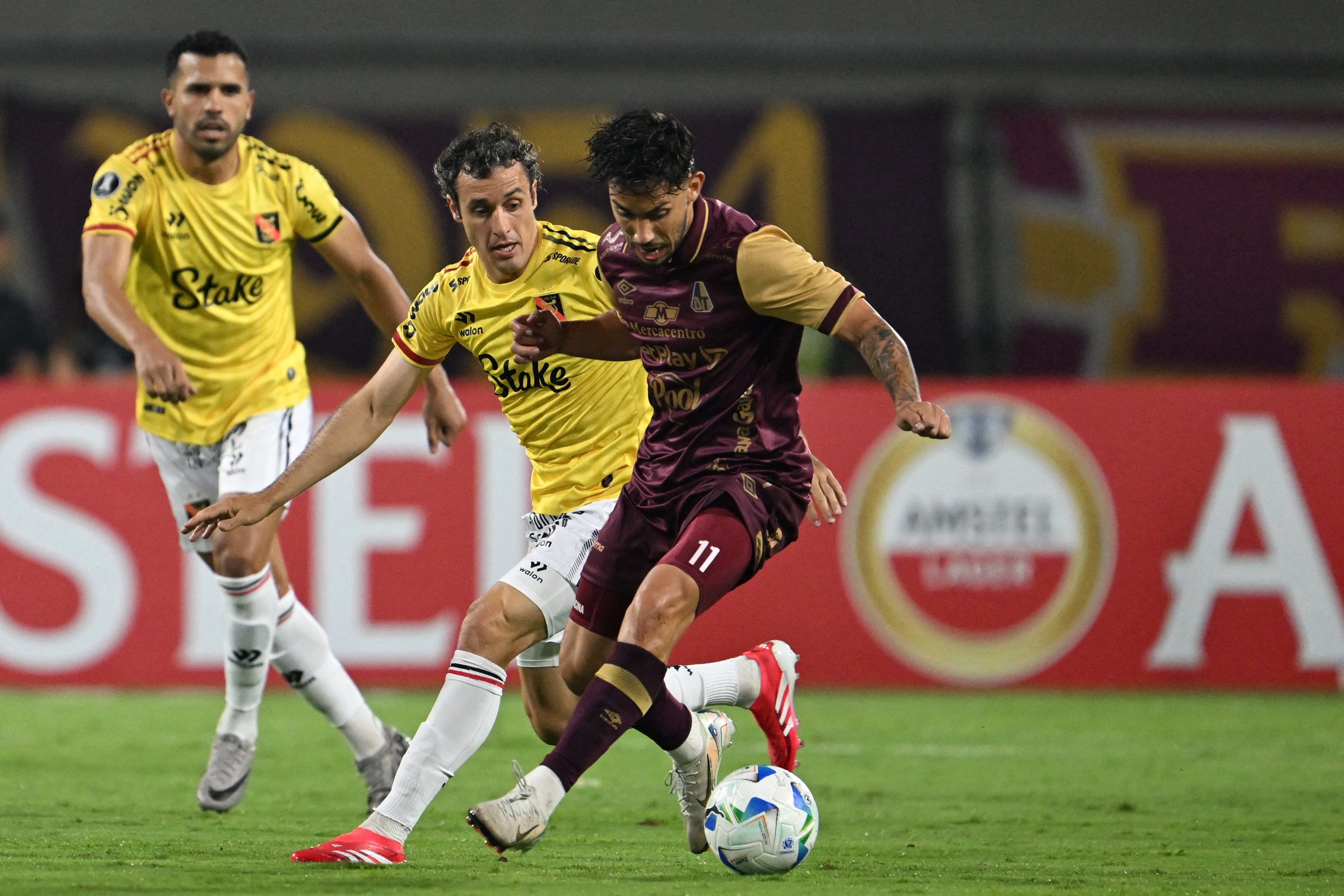 Tolima's Argentine forward #11 Gonzalo Lencina (R) and Melgar's Argentine midfielder #15 Horacio Orzan fight for the ball during the Copa Libertadores qualification second round first leg football match between Colombia's Deportes Tolima and Peru's Melgar at the Manuel Murillo Toro stadium in Ibague, Colombia, on February 20, 2025. (Photo by RAUL ARBOLEDA / AFP) (Photo by RAUL ARBOLEDA/AFP via Getty Images)          