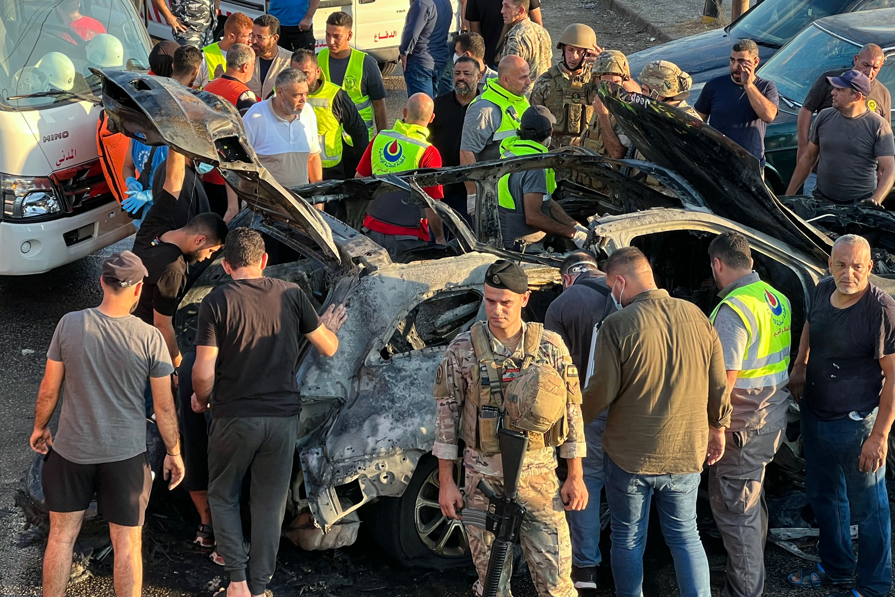 Lebanese security forces and forensic check a burnt car following an Israeli strike in the southern Lebanese city of Sidon on August 9, 2024. A Lebanese security source said the Israeli strike on a vehicle in the southern city of Sidon killed a Hamas security official from the nearby Ain al-Helweh Palestinian refugee camp. (Photo by Mahmoud ZAYYAT / AFP) (Photo by MAHMOUD ZAYYAT/AFP via Getty Images)