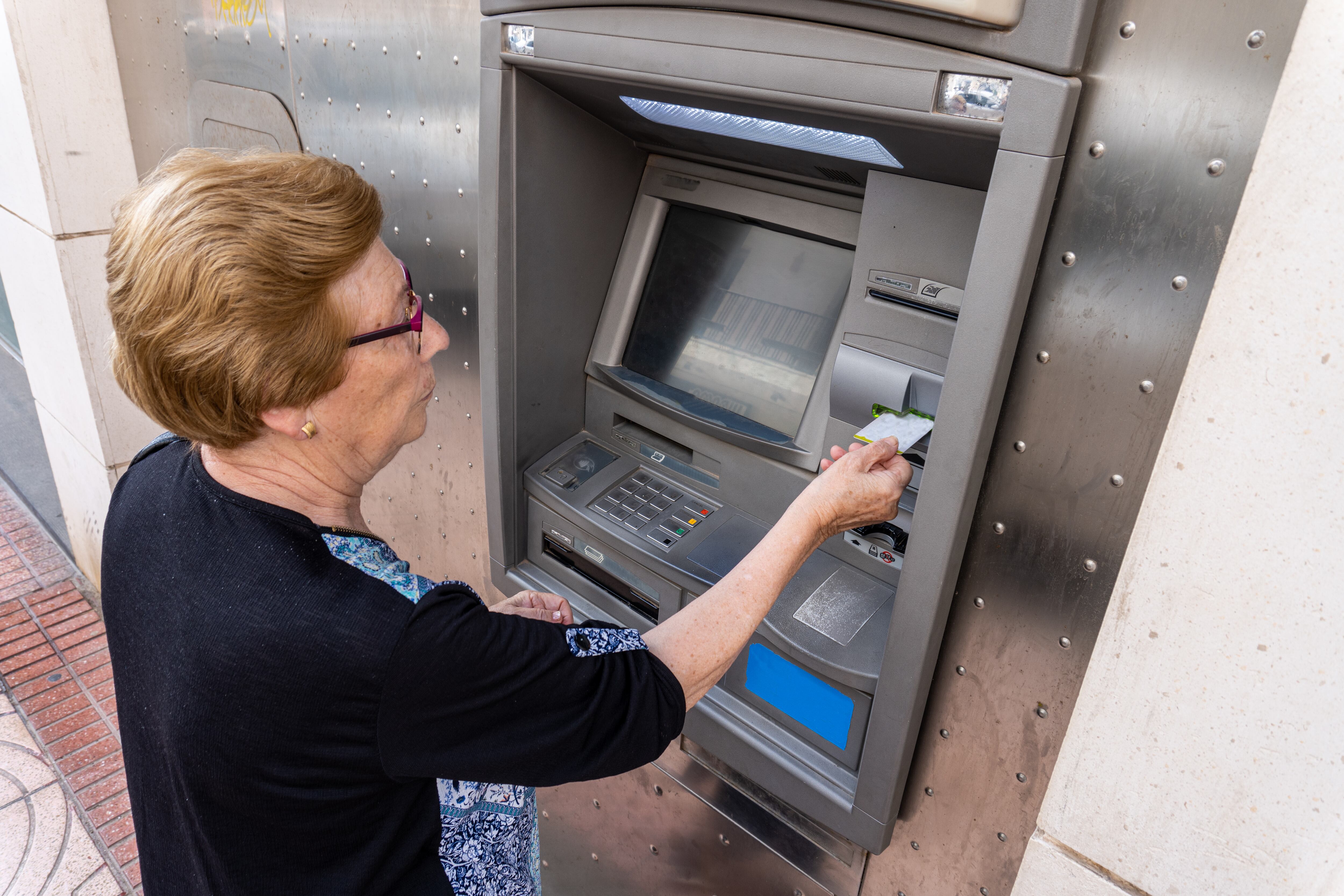 Mujer anciana retirando dinero de un cajero electrónico (Foto vía Getty Images)