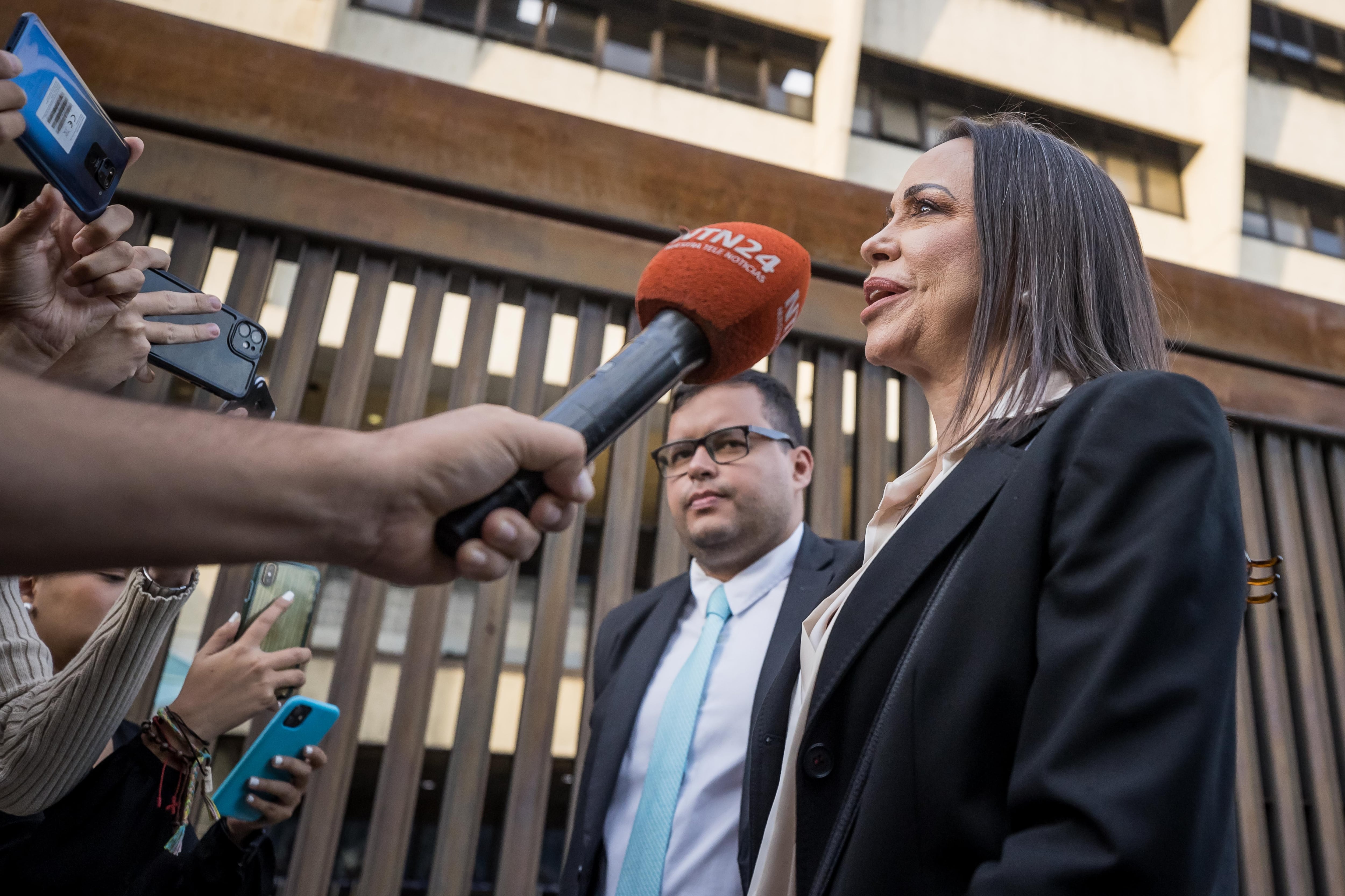 AME4581. CARACAS (VENEZUELA), 15/12/2023.- María Corina Machado habla con periodistas en la salida del Tribunal Supremo de Justicia, hoy en Caracas (Venezuela). La candidata presidencial de la principal coalición opositora de Venezuela, María Corina Machado, solicitó al Tribunal Supremo de Justicia (TSJ) revisar la inhabilitación que le impide competir para ocupar cargos de elección popular, corroboró este viernes EFE. EFE/ Miguel Gutiérrez