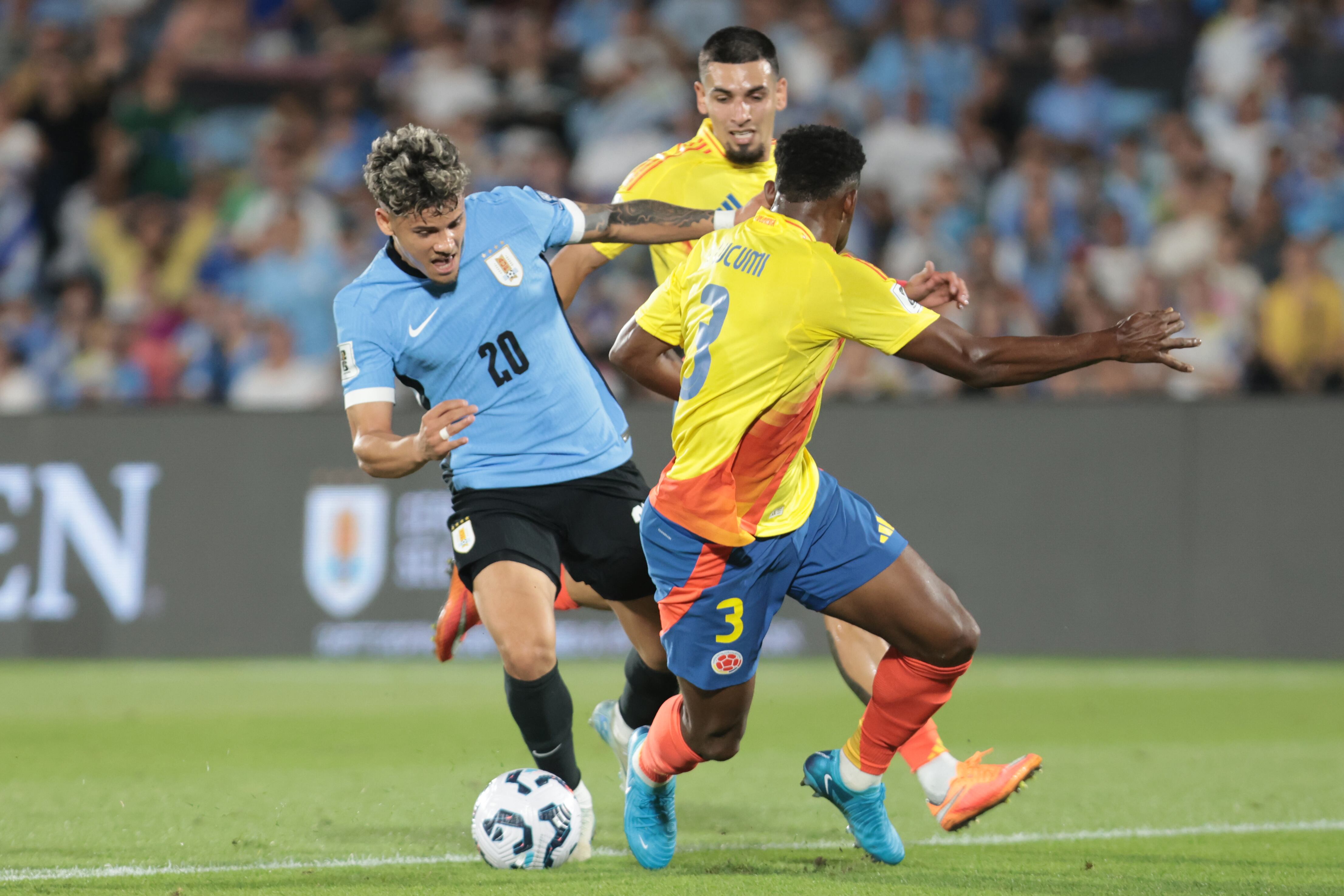 Maximiliano Araújo (i) de Uruguay disputa el balón con Jhon Lucumí de Colombia este viernes, durante un partido de las eliminatorias sudamericanas al Mundial de Fútbol 2026, entre Uruguay y Colombia en el estadio Centenario, en Montevideo (Uruguay). EFE/ Gastón Britos