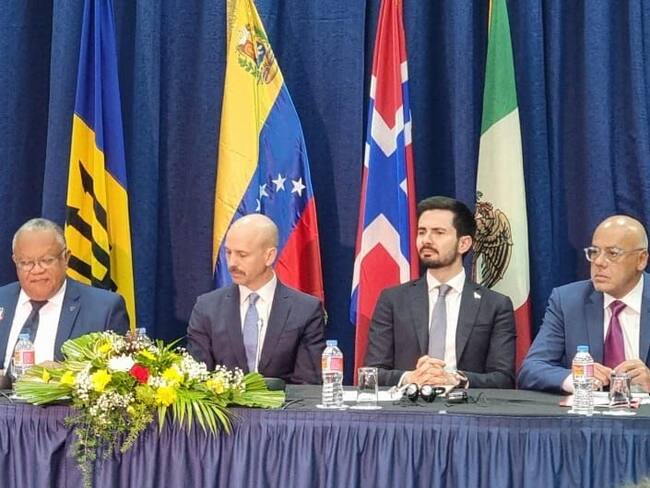 Los jefes de las delegaciones de la oposición y el gobierno de Venezuela, Gerardo Blyde y Jorge Rodríguez, respectivamente acompañados por Dag Nylander, representante de Noruega. Foro: delegación opositora