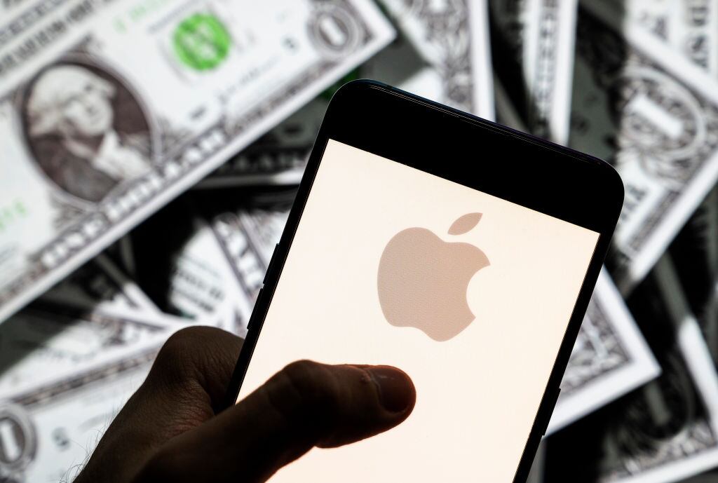 Logo de Apple con varios billetes de dólar. I Foto: Budrul Chukrut/SOPA Images/LightRocket via Getty Images.