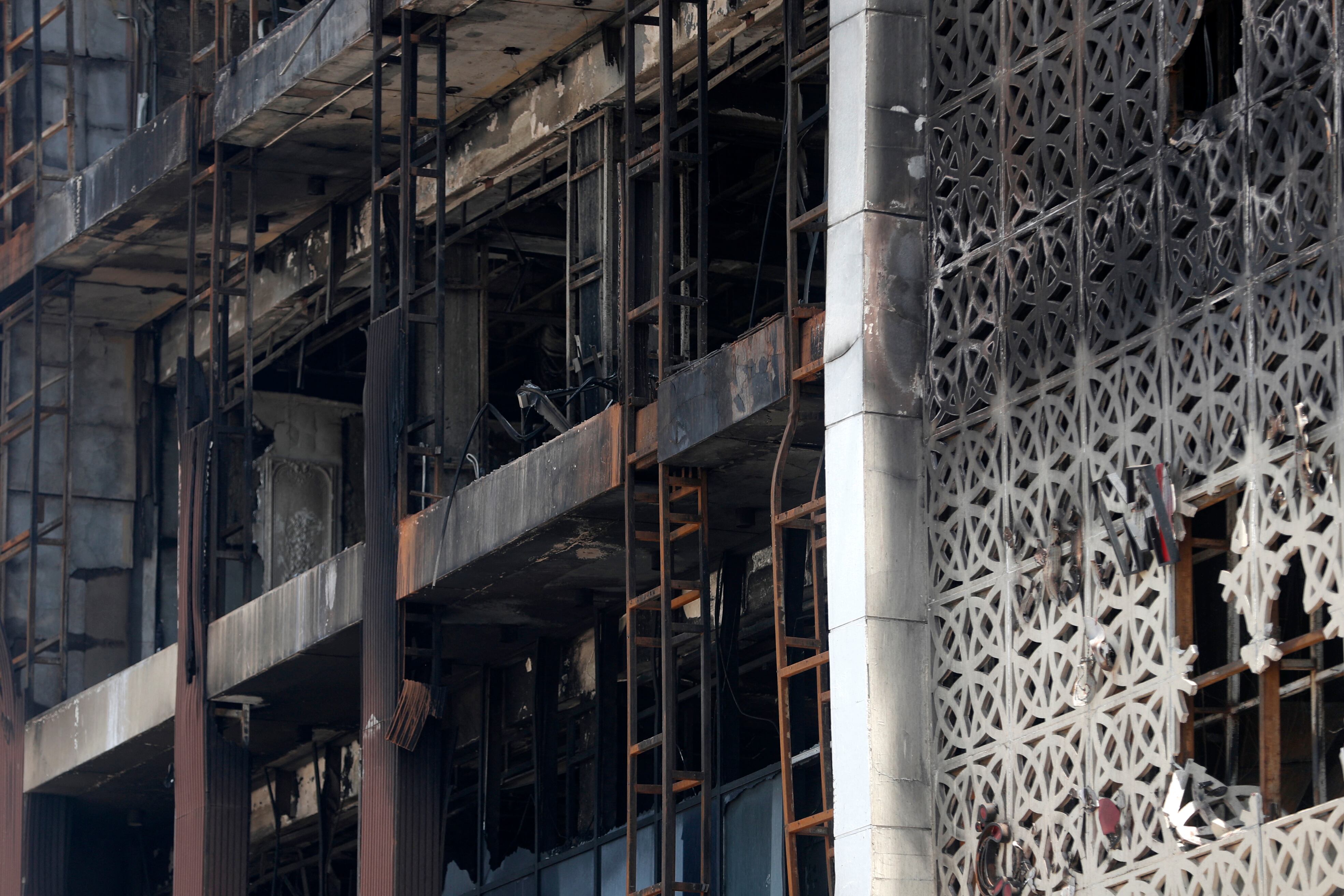 A close up shot shows on July 17, 2025 the damaged facade after a fire tore through the newly opened Hyper Mall overnight in the eastern Iraqi city of Kut, killing at least 60 people, according to Iraqi authorities. Officials have launched an investigation into the blaze, the latest in a country where safety regulations are frequently neglected. (Photo by AHMAD AL-RUBAYE / AFP)