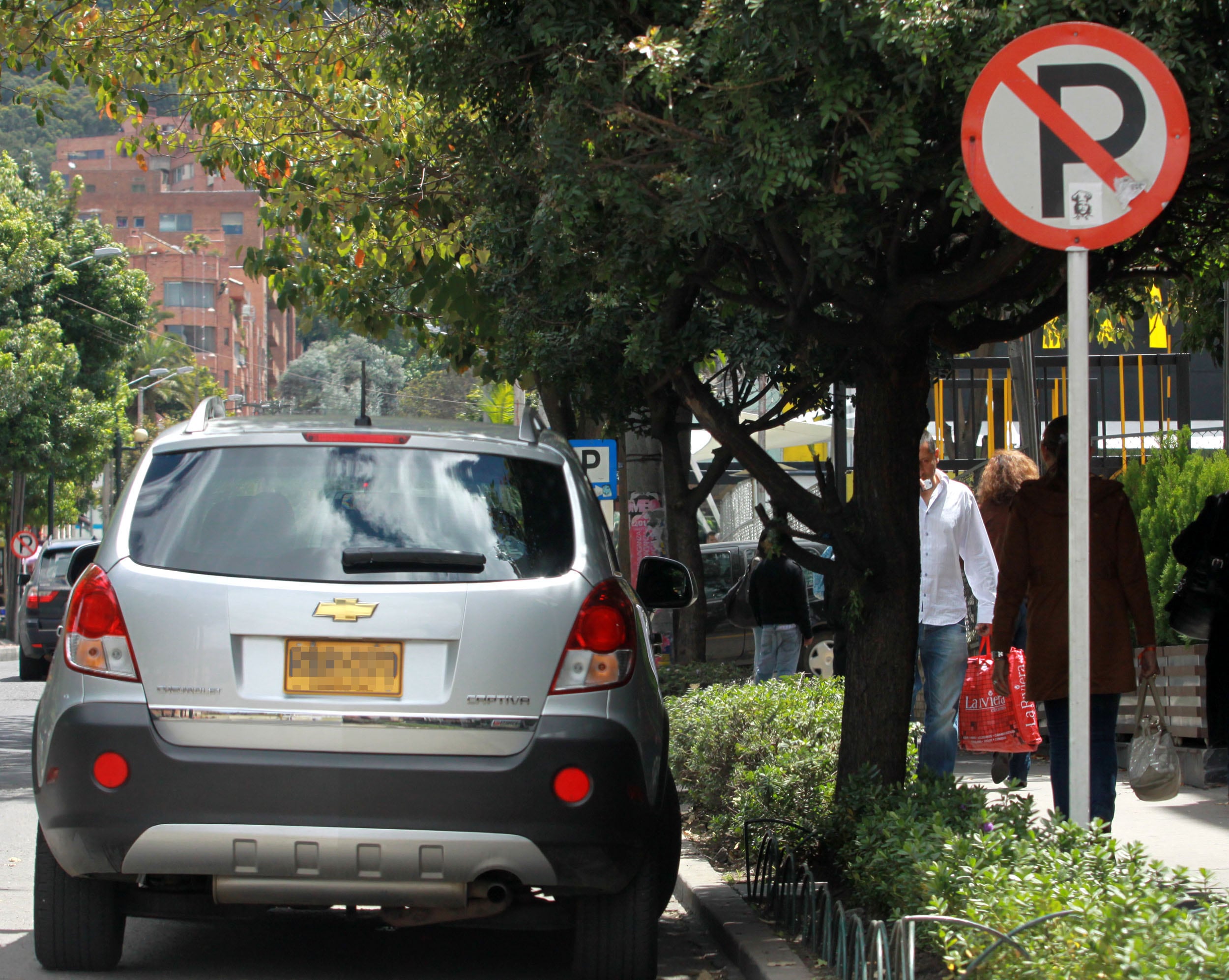 Carro mal estacionado al lado de una señal de prohibido parquear (Colprensa)