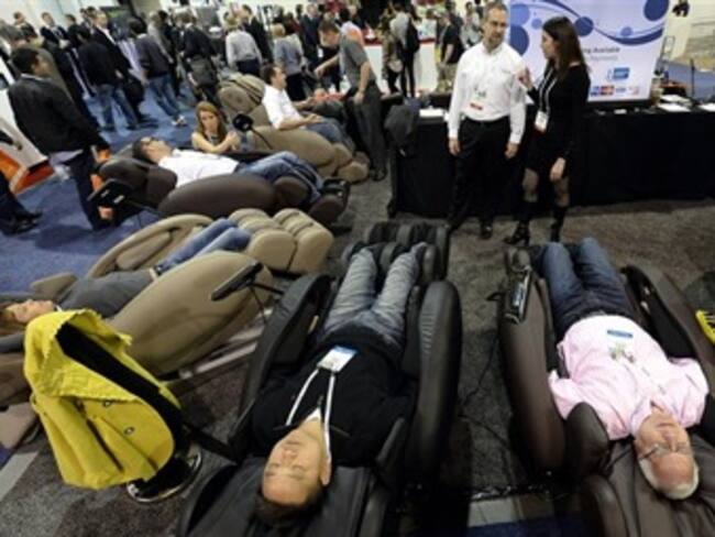 Asistentes prueban la silla de masajes Infinity que se exhibe en la Feria Internacional CES. Foto: Efe.