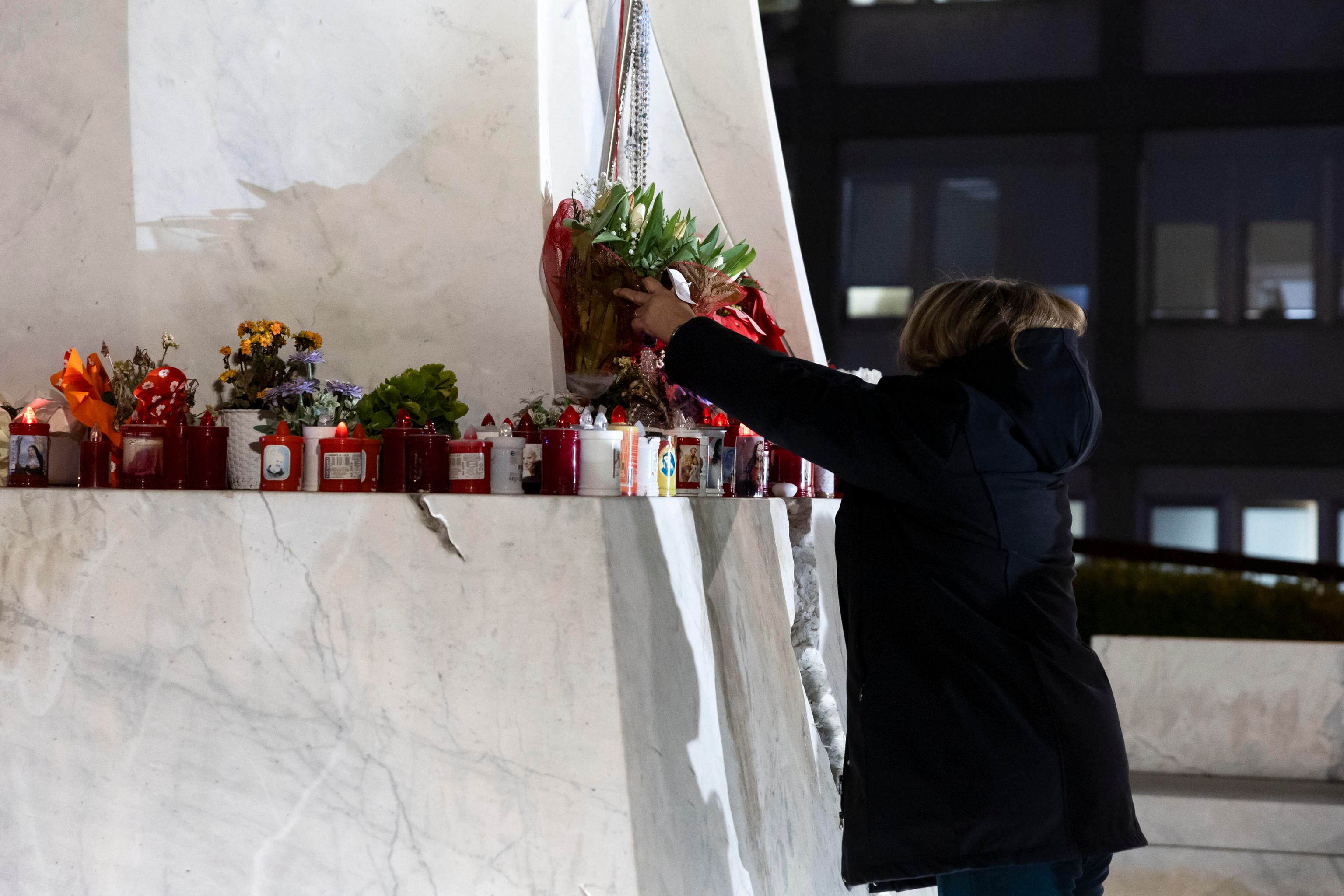 ROMA (Italia), 18/02/2025.- Una persona coloca flores y velas durante una oración de la comunidad boliviana en el Hospital Gemelli, donde está hospitalizado el Papa Francisco.