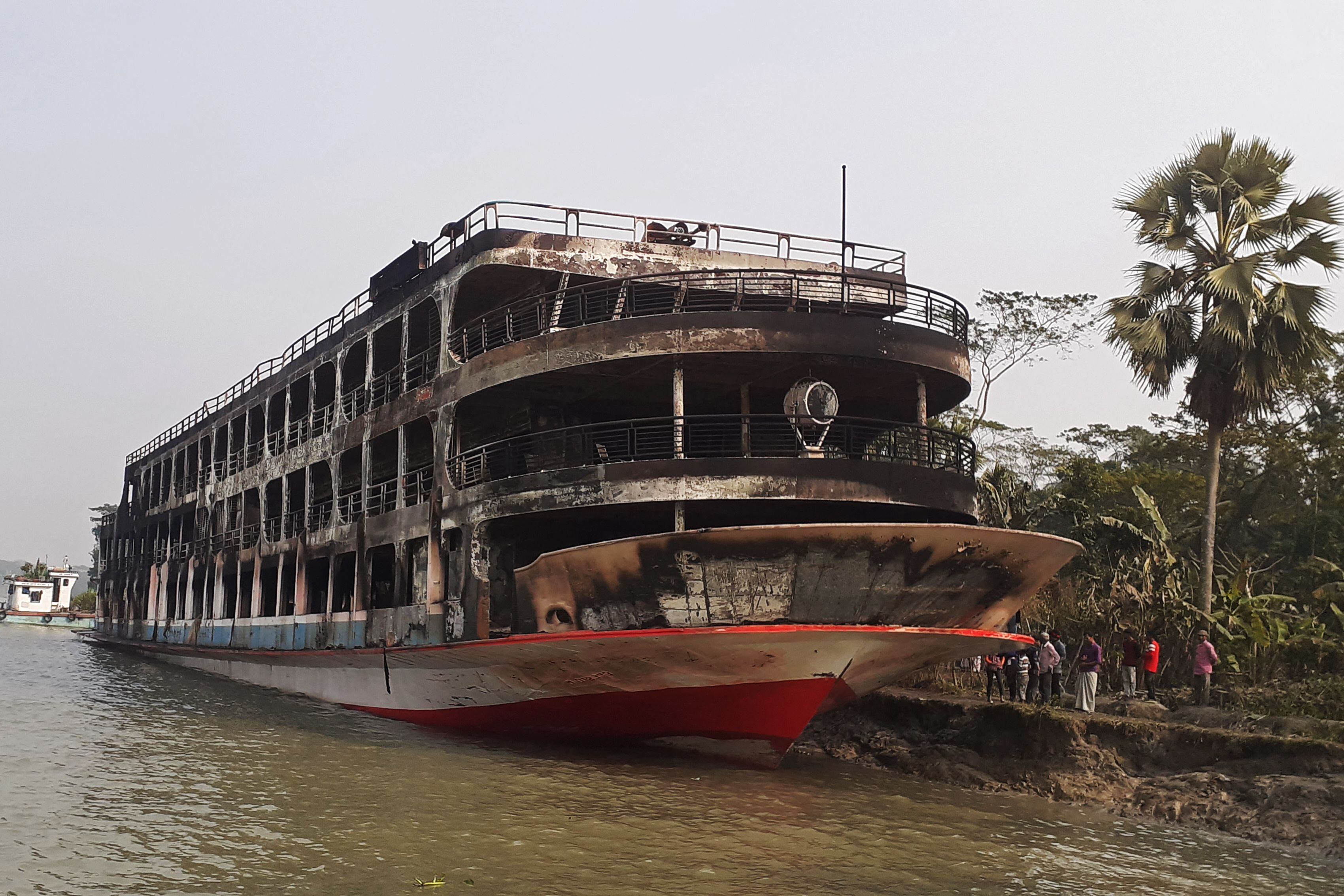 The burnt-out ferry is seen anchored along a coast a day after it caught fire killing at least 37 people in Jhalkathi, 250 km (160 miles) south of Dhaka on December 24, 2021. (Photo by arifur rahman / AFP) (Photo by ARIFUR RAHMAN/AFP via Getty Images)
