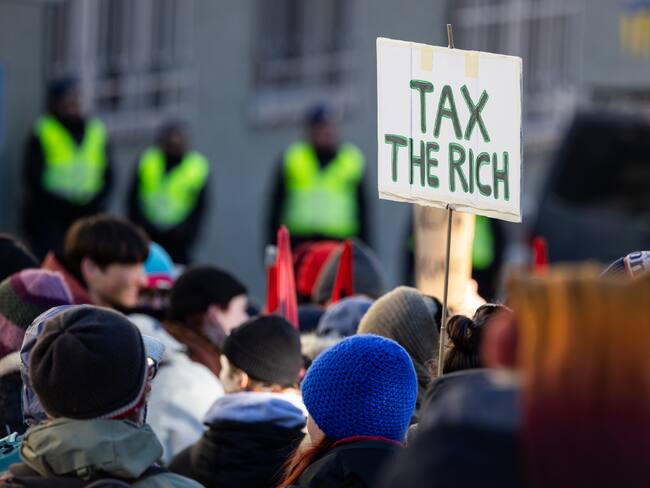 14 de enero de 2024, Suiza, Davos: Un cartel reza «Impuestos a los ricos». Cientos de personas se manifestaron por la justicia climática tras un estudio de Oxfam que señala que los superricos se hacen más ricos pese a la inflación y las crisis. (Hannes P Albert/picture alliance vía Getty Images)
