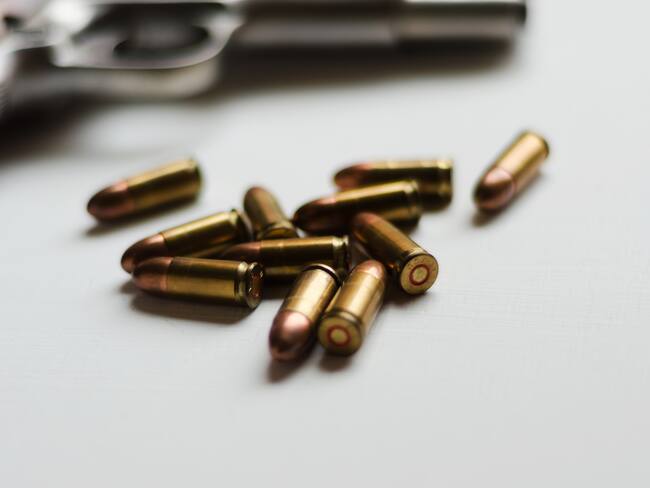 A handgun with ammunition on white background. Photo: Getty Images.
