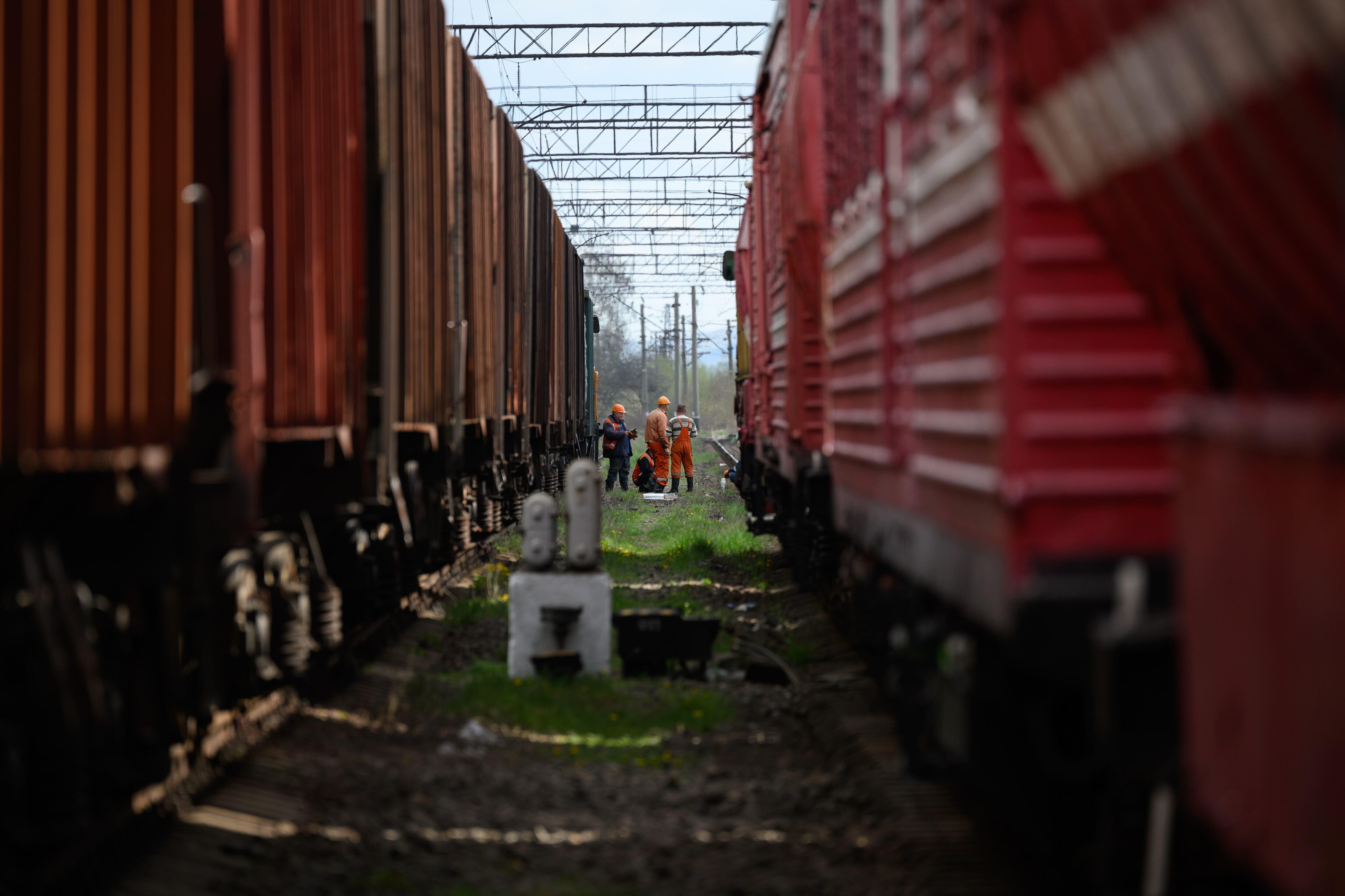 LVIV, UKRAINE - APRIL 25: Rail workers wait between two train lines, near to the site of a missile strike on April 25, 2022 near Lviv, Ukraine. The head of Ukrainian Railways said in a social media post today that five rail facilities had been attacked by Russia this morning, including a "traction substation," a facility supplying power to overhead lines, in Krasne, near Lviv. (Photo by Leon Neal/Getty Images)