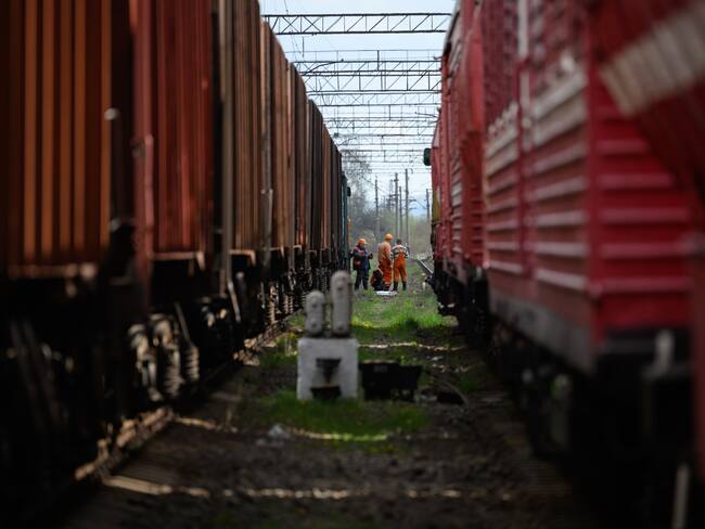 LVIV, UKRAINE - APRIL 25: Rail workers wait between two train lines, near to the site of a missile strike on April 25, 2022 near Lviv, Ukraine. The head of Ukrainian Railways said in a social media post today that five rail facilities had been attacked by Russia this morning, including a &quot;traction substation,&quot; a facility supplying power to overhead lines, in Krasne, near Lviv. (Photo by Leon Neal/Getty Images)