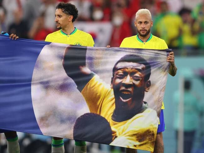 Neymar y Marquinhos de Brasil sostienen una pancarta en apoyo del ex jugador brasileño Pelé en la Copa Mundial de la FIFA Qatar 2022. Foto de Marc Atkins/Getty Images.