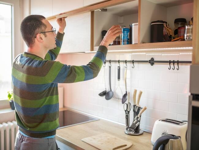 Hombre buscando qué comer en la lacena de la cocina // Imagen de referencia: Getty Images