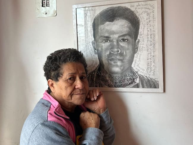 Blanca Nubia junto a la foto del recuero de su hijo Julián Oviedo, víctima de las ejecuciones extrajudiciales.