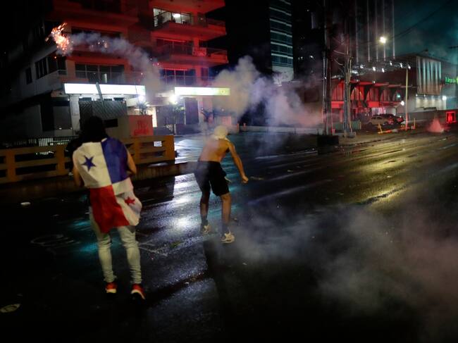 AME976. CIUDAD DE PANAMÁ (PANAMÁ), 26/10/2023.- Manifestantes se enfrentan hoy con policías antidisturbios durante protestas contra la concesión a la minera canadiense FQM, en Ciudad de Panamá (Panamá). Cientos de manifestantes recorrieron este jueves las principales calles de Ciudad de Panamá hasta llegar a las proximidades de la sede presidencial, donde hubo enfrentamientos con la policía, en rechazo a la renovada concesión dada a la empresa Minera Panamá, filial de la canadiense First Quantum Minerals (FQM). EFE/ Bienvenido Velasco