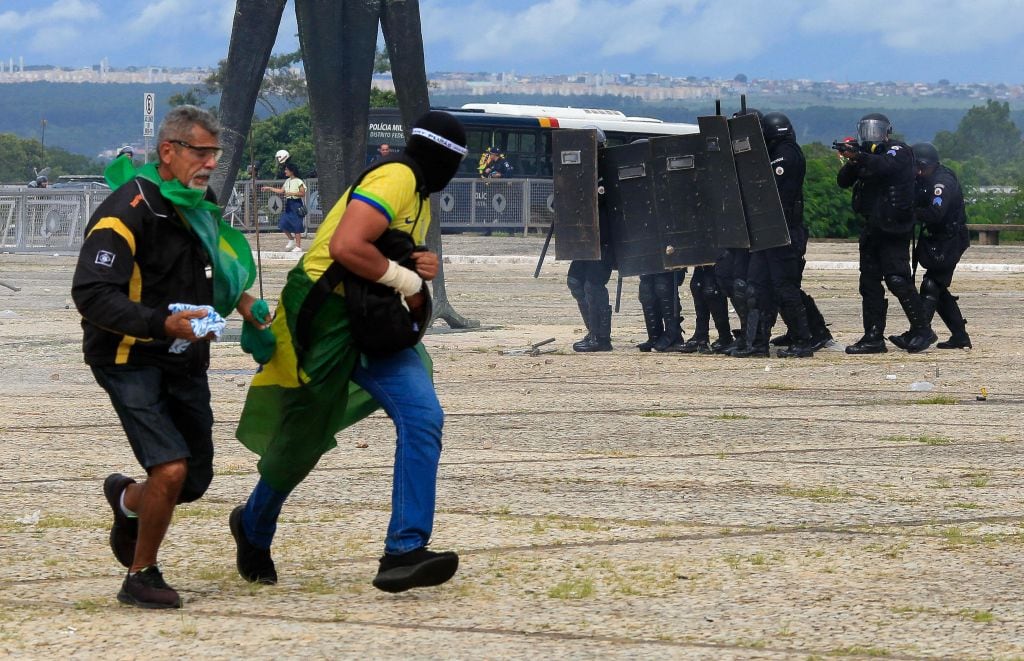 Security forces confront supporters of Brazilian former President Jair Bolsonaro as they invade Planalto Presidential Palace in Brasilia on January 8, 2023. - Hundreds of supporters of Brazil's far-right ex-president Jair Bolsonaro broke through police barricades and stormed into Congress, the presidential palace and the Supreme Court Sunday, in a dramatic protest against President Luiz Inacio Lula da Silva's inauguration last week. (Photo by Sergio Lima / AFP) (Photo by SERGIO LIMA/AFP via Getty Images)