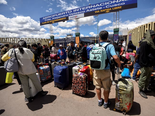 Los viajeros hacen cola afuera del aeropuerto internacional Alejandro Velasco Astete en la ciudad de Cusco, Perú, esperando su turno para ingresar y abordar sus vuelos el 20 de enero de 2023. Foto de IVAN FLORES/AFP vía Getty Images.