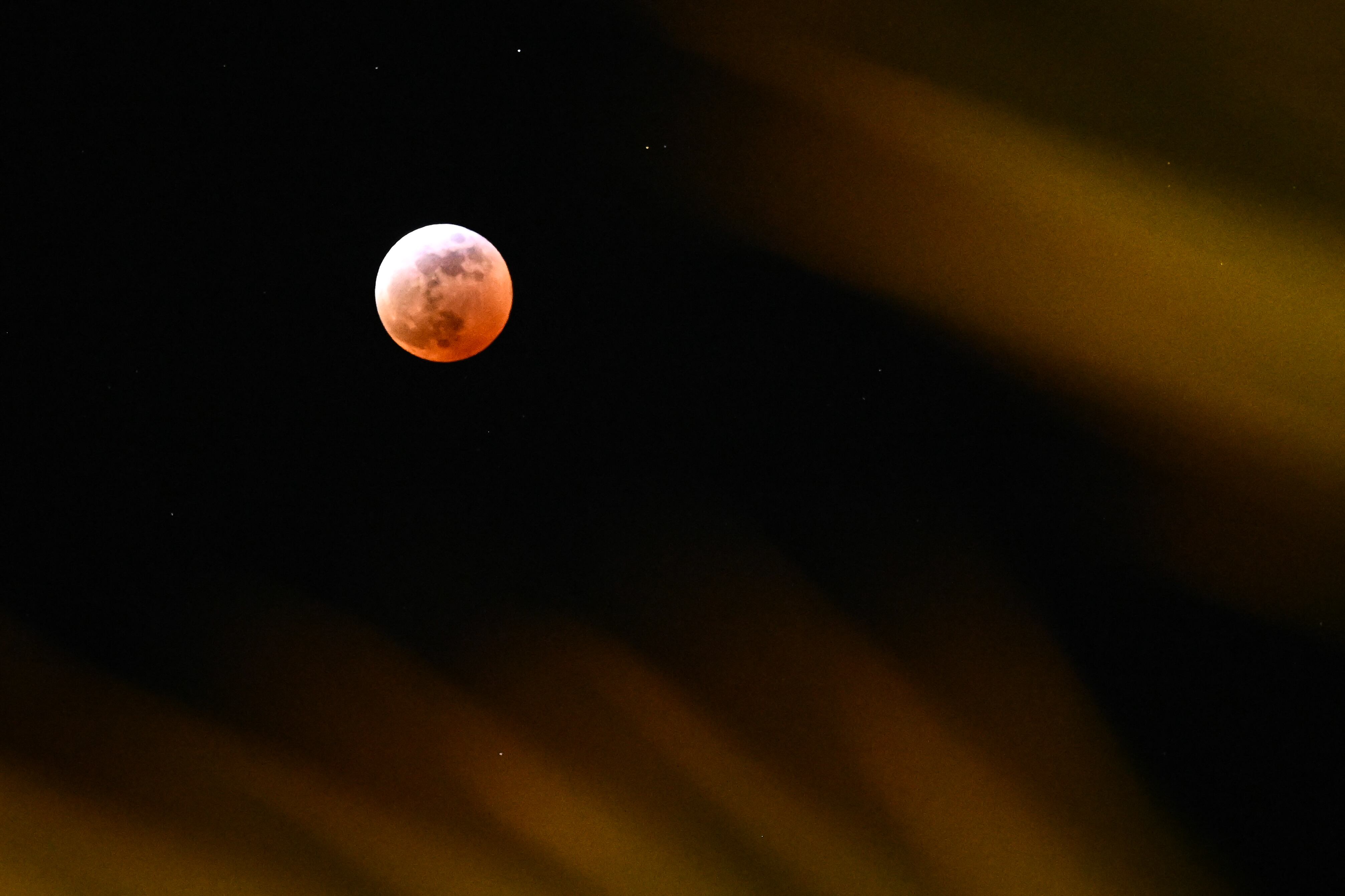 Un eclipse lunar parcial se ve por encima de las hojas de una palmera durante el eclipse lunar de Luna de Sangre en Palm Springs, California (Estados Unidos), el 13 de marzo de 2025. AFP