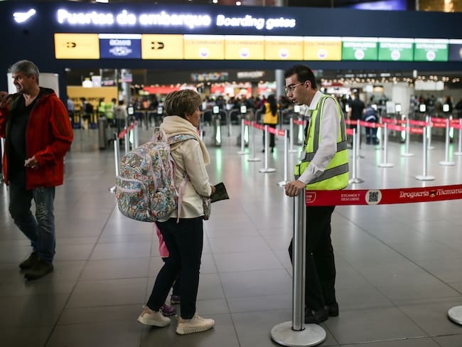 Mujer resolviendo dudas con personal del Aeropuerto del Dorado en Bogotá (Getty Images)
