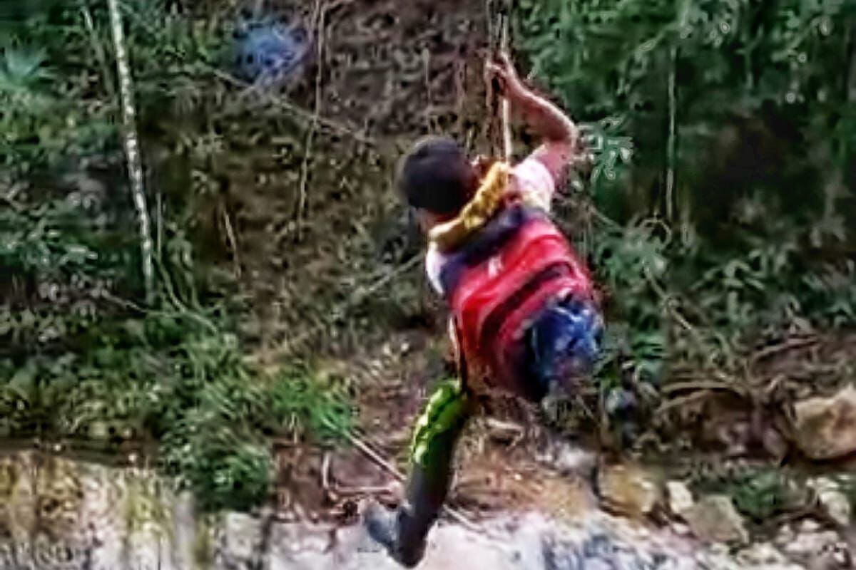 Los niños hacen uso de una garrucha improvisada e instalada por los padres de familia, a pesar del riesgo de sufrir un accidente. Crédito: Comité de Salud de Playa Rica.