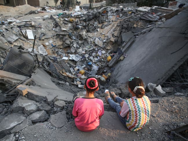 Niños palestinos inspeccionan su edificio dañado en la ciudad de Gaza el 9 de agosto de 2022 después de que entró en vigor un alto el fuego entre Israel y los militantes palestinos. (Photo by Majdi Fathi/NurPhoto via Getty Images)