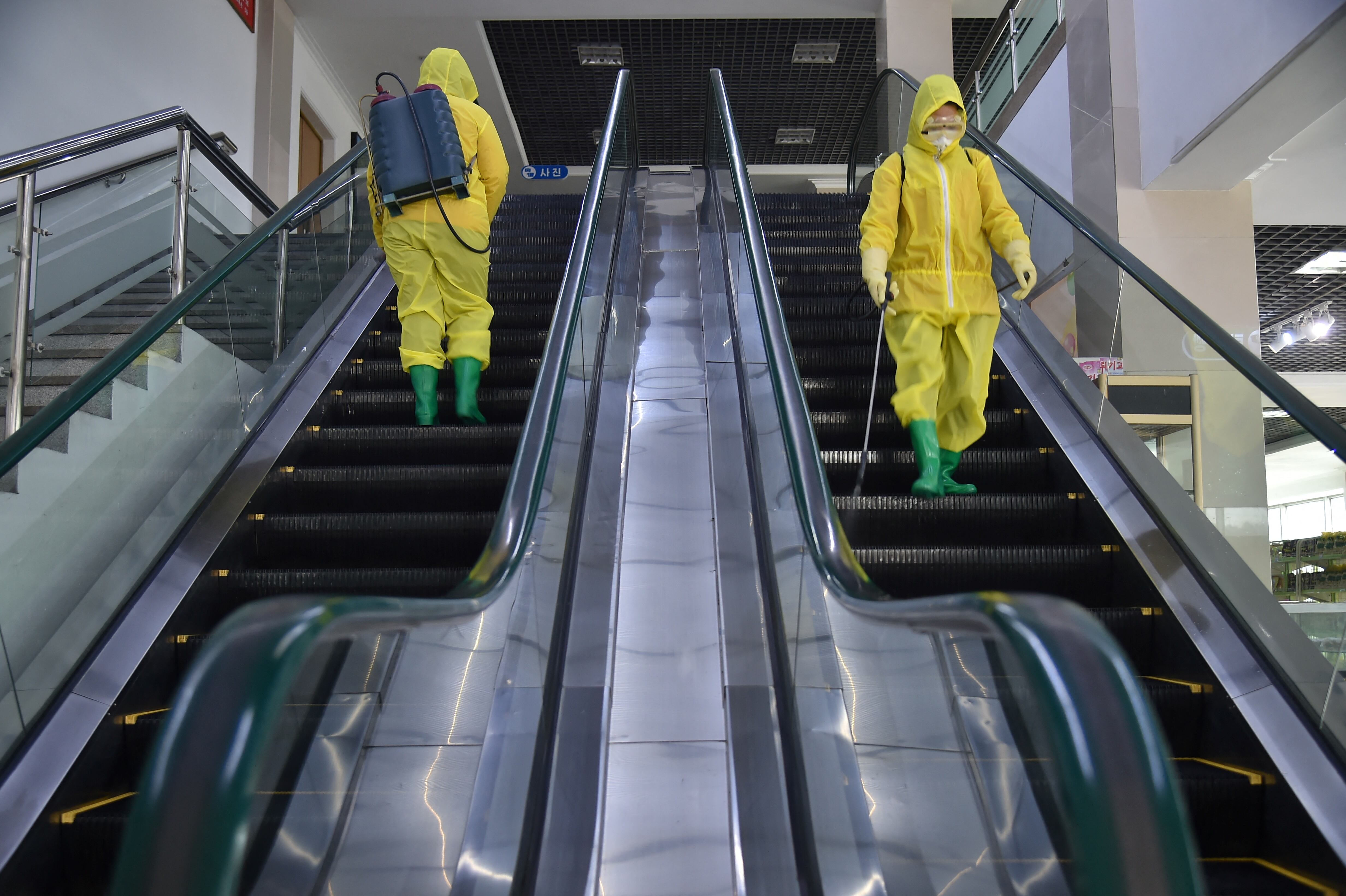TOPSHOT - Employees spray disinfectant as part of preventative measures against the Covid-19 coronavirus at the Pyongyang Children's Department Store in Pyongyang on March 18, 2022. (Photo by KIM Won Jin / AFP) (Photo by KIM WON JIN/AFP via Getty Images)