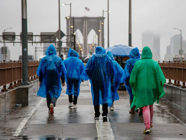 New York (United States), 29/09/2023.- People walk across the Brooklyn Bridge in the heavy rain in New York, New York, USA, 29 September 2023. New York Governor Kathy Hochul declared a State of Emergency as flash flooding affects the New York City area due to heavy rain. (Nueva York) EFE/EPA/SARAH YENESEL